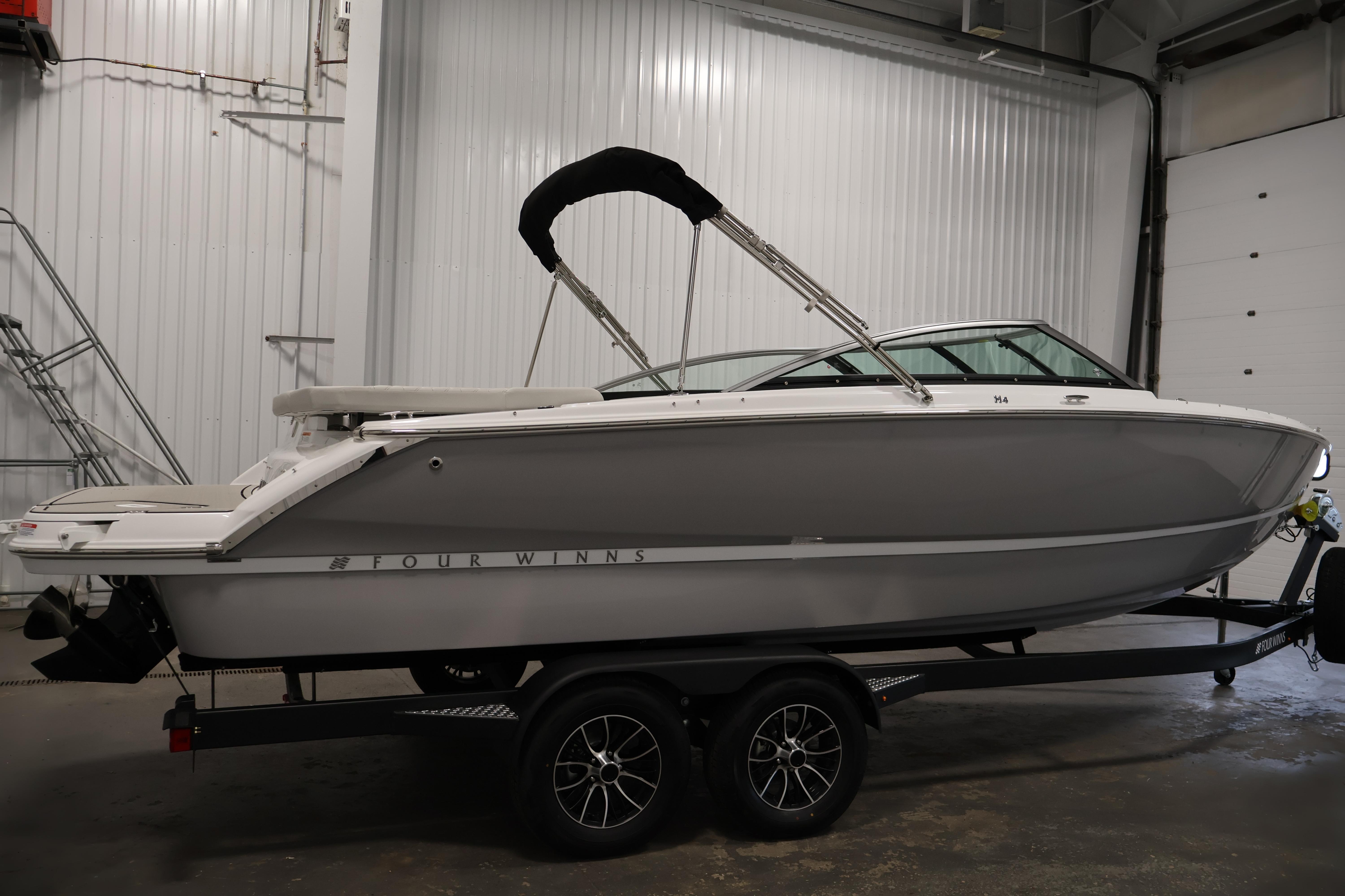 2026 Four Winns H4 Freedom boat on trailer in indoor storage facility.