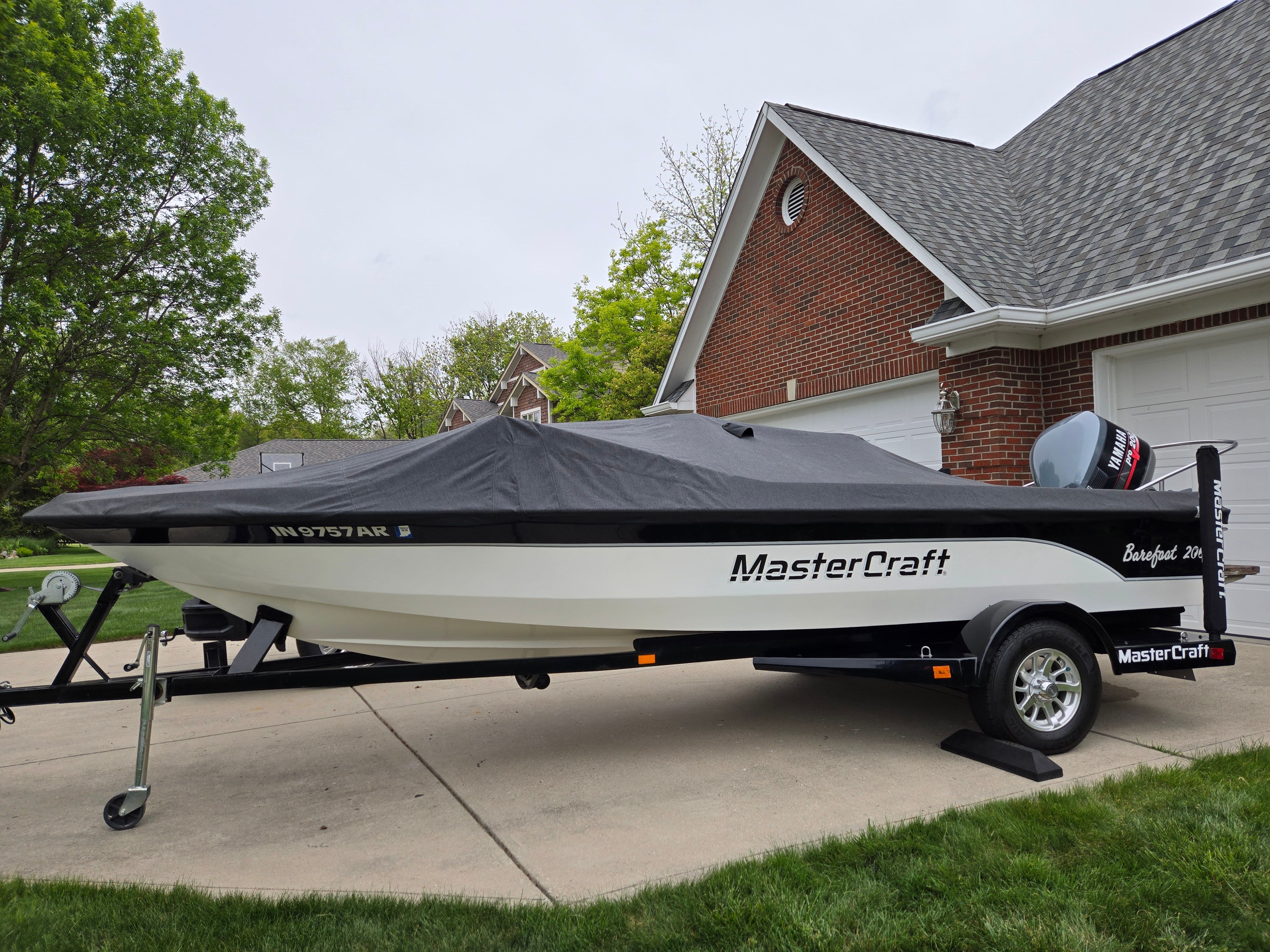 1991 MasterCraft Barefoot 200 boat with cover on driveway.
