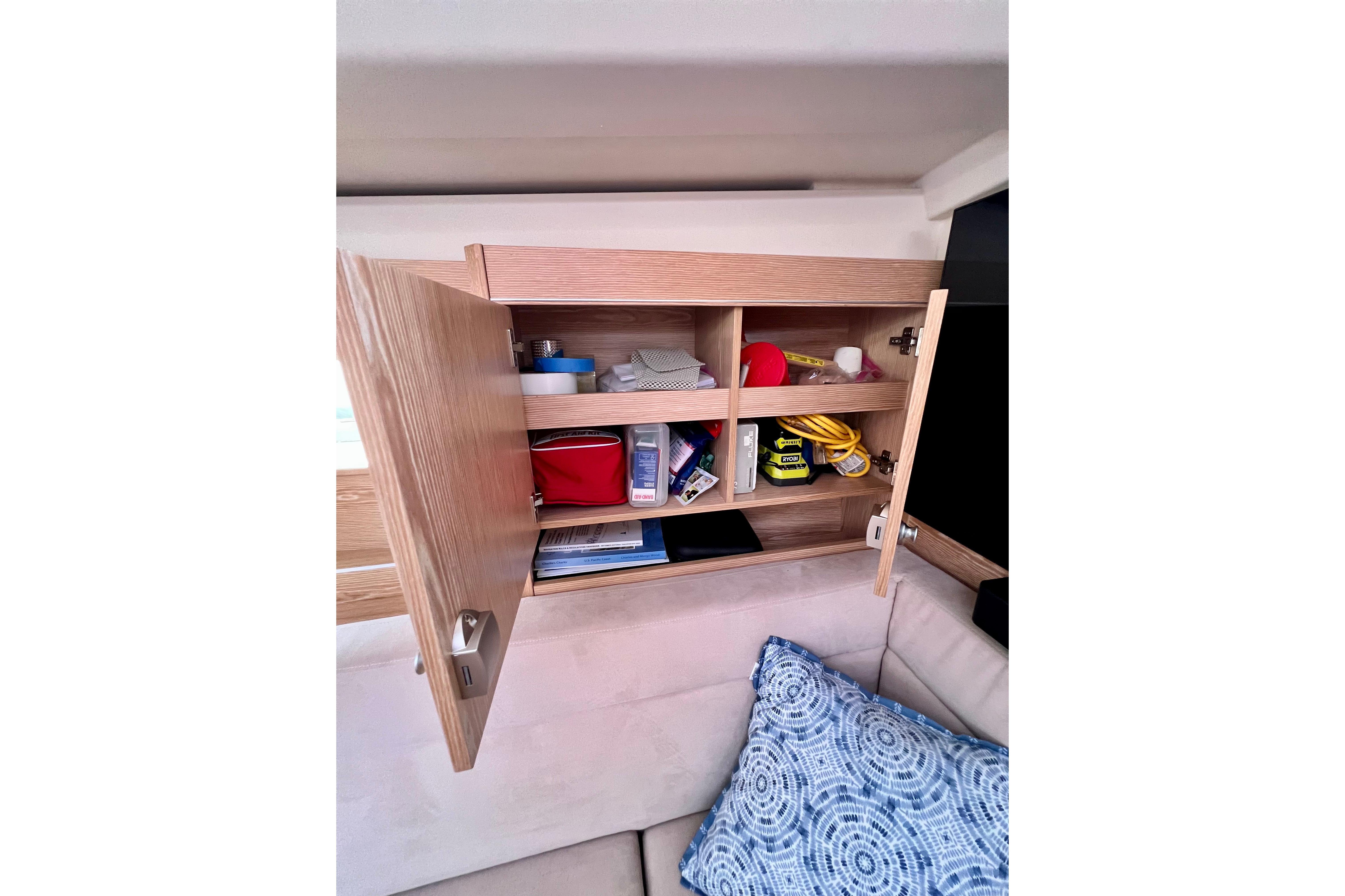 Open wooden cabinet on 2016 Hanse 455 yacht, displaying organized storage shelves.