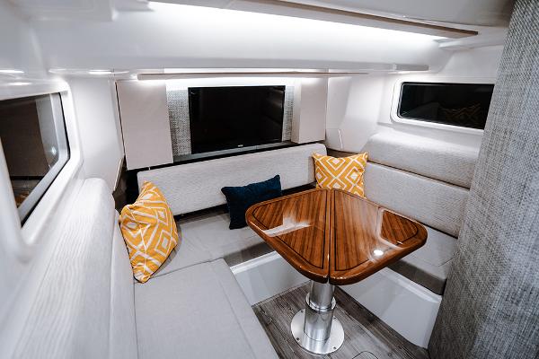 Manufacturer Provided Image: Luxurious interior of 2025 Everglades 455 Center Console with elegant seating and wooden table.