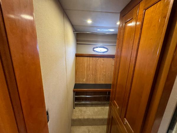 2003 Cruisers Yachts 540 Express interior hallway with wooden cabinetry and porthole window.