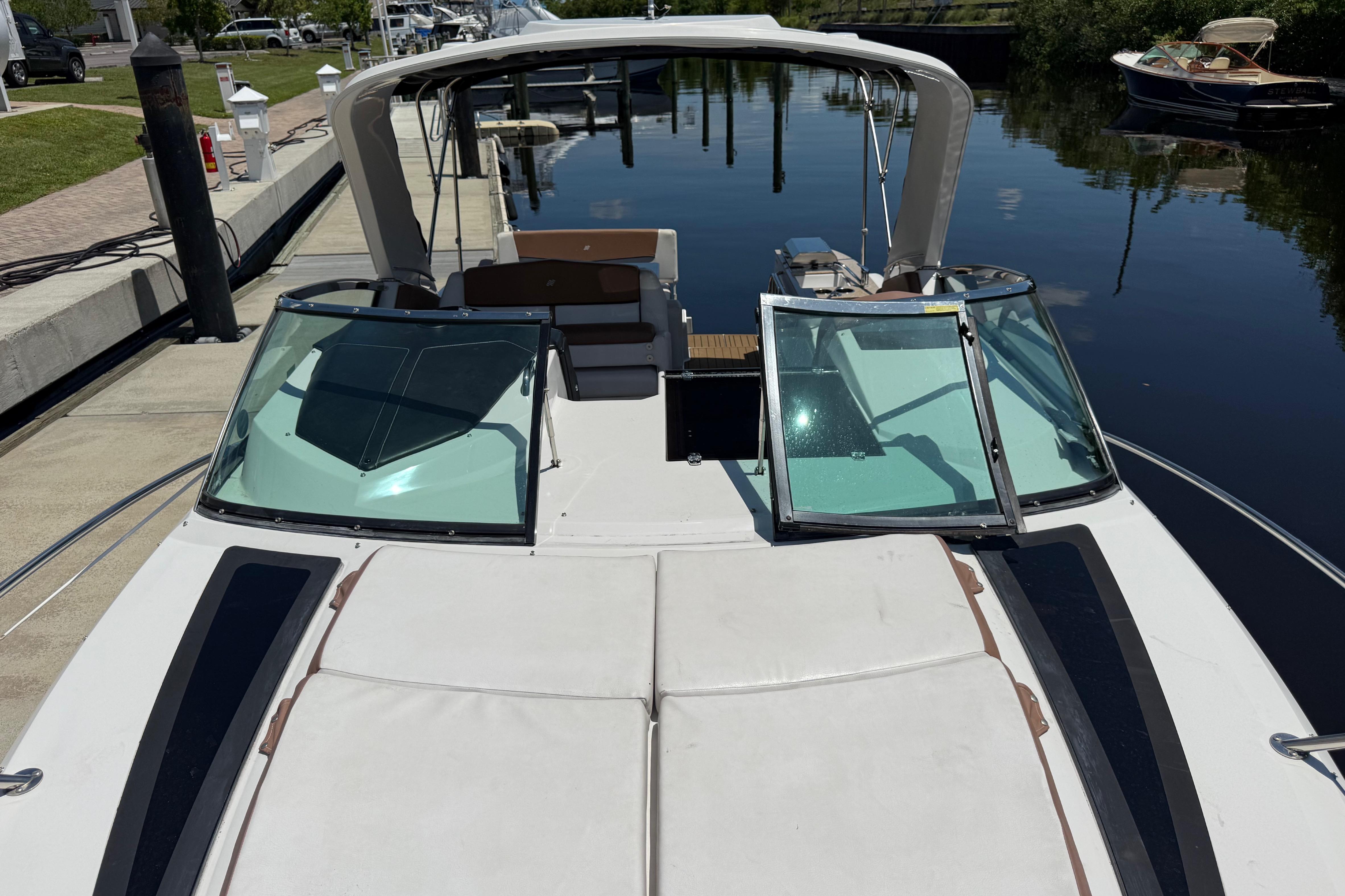 2017 Four Winns V275 boat docked by a calm waterfront.