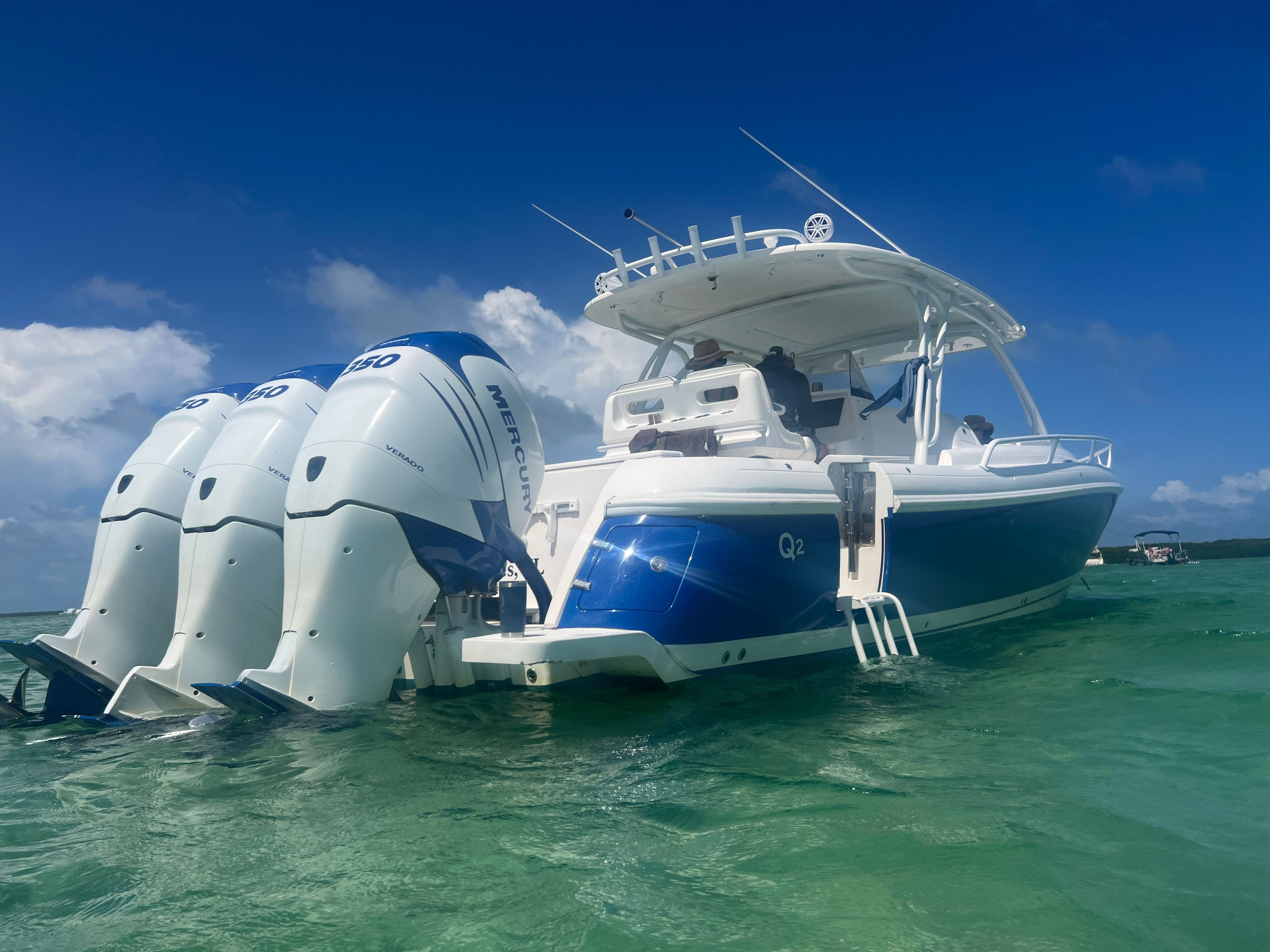 A 2014 Intrepid 375 Walkaround with three outboard engines in clear, turquoise water.