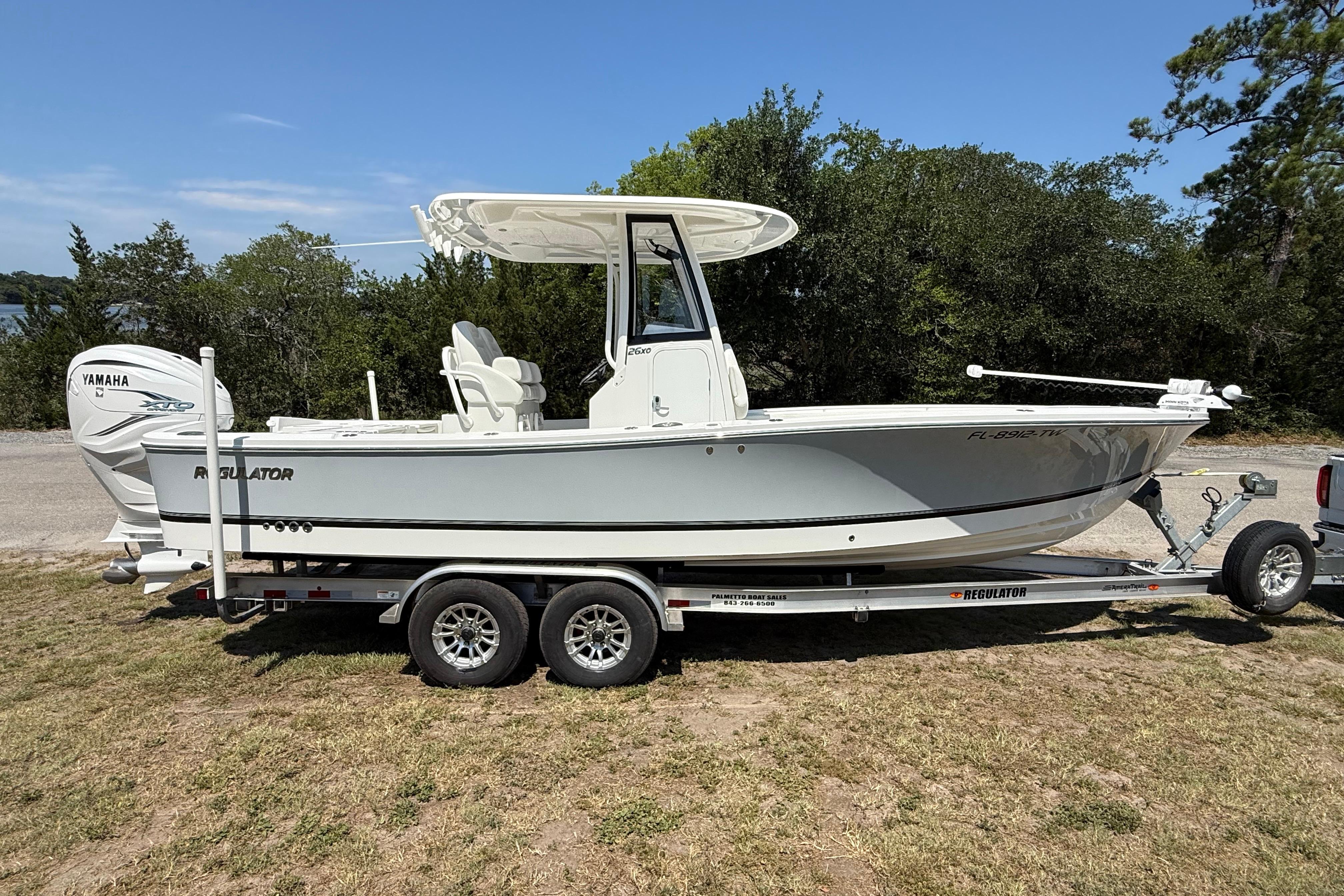 2023 Regulator 26XO boat on trailer, featuring Yamaha engine, parked outdoors.