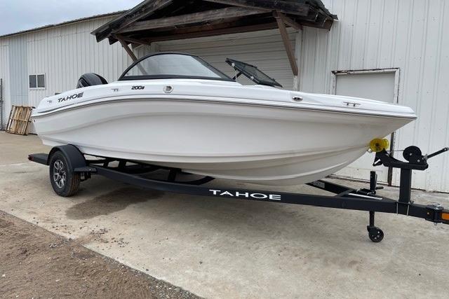 2025 Tahoe 200 S boat on trailer, parked outside a white building.