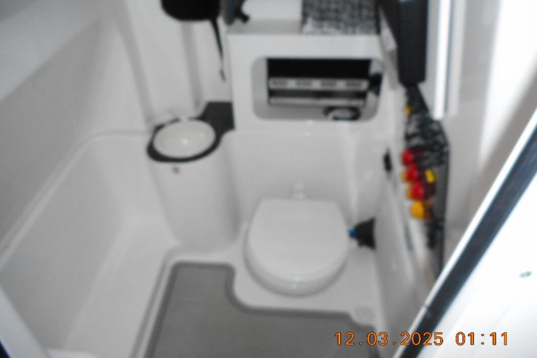 Interior of 2023 Sea Fox 288 Commander boat bathroom with toilet and storage.