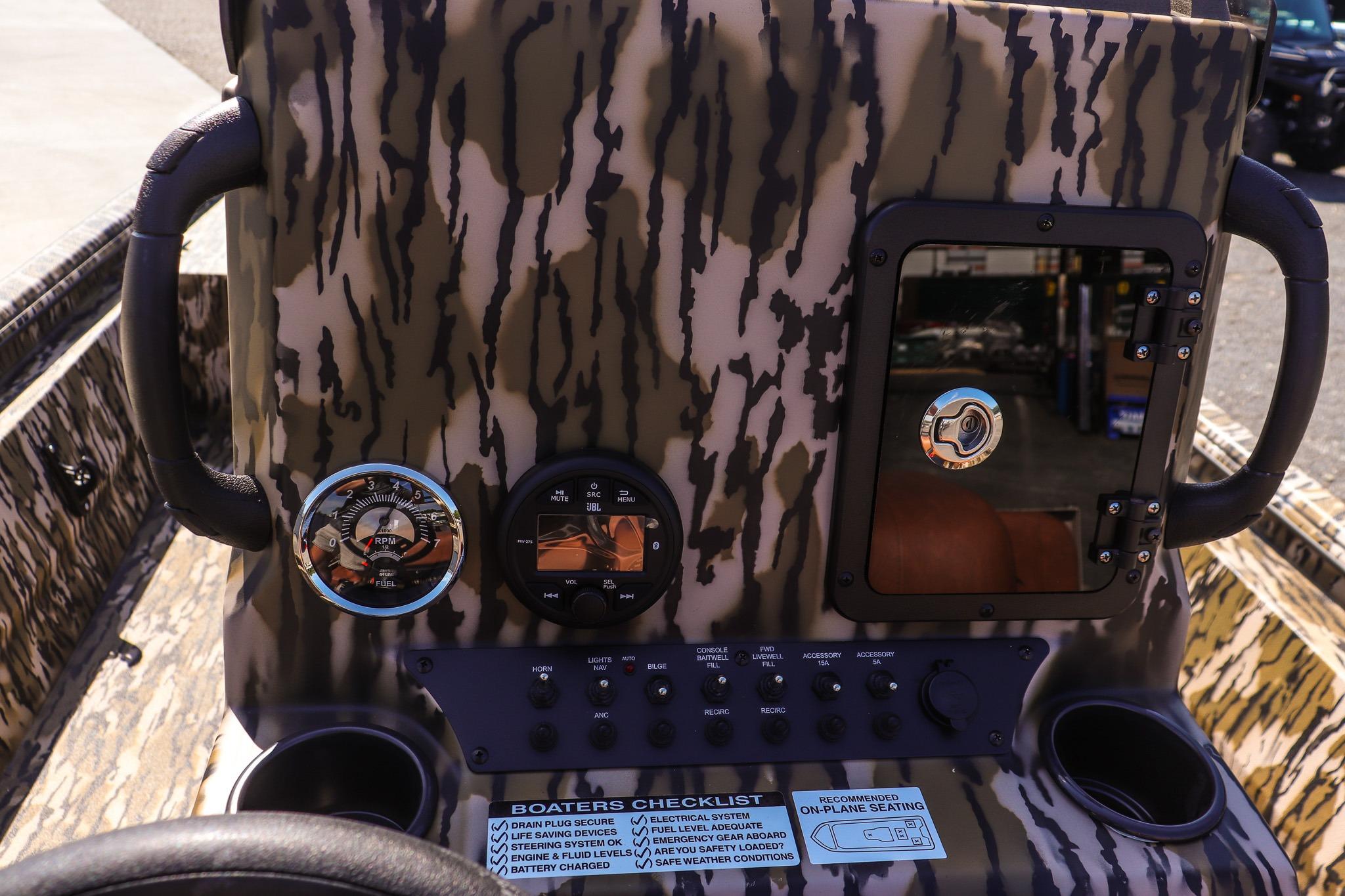 Dashboard of an Avid 20 Rogue CC boat with camouflage pattern and various instruments.