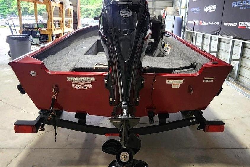 2026 Tracker Super Guide V-16 SC boat with outboard motor in a garage setting.