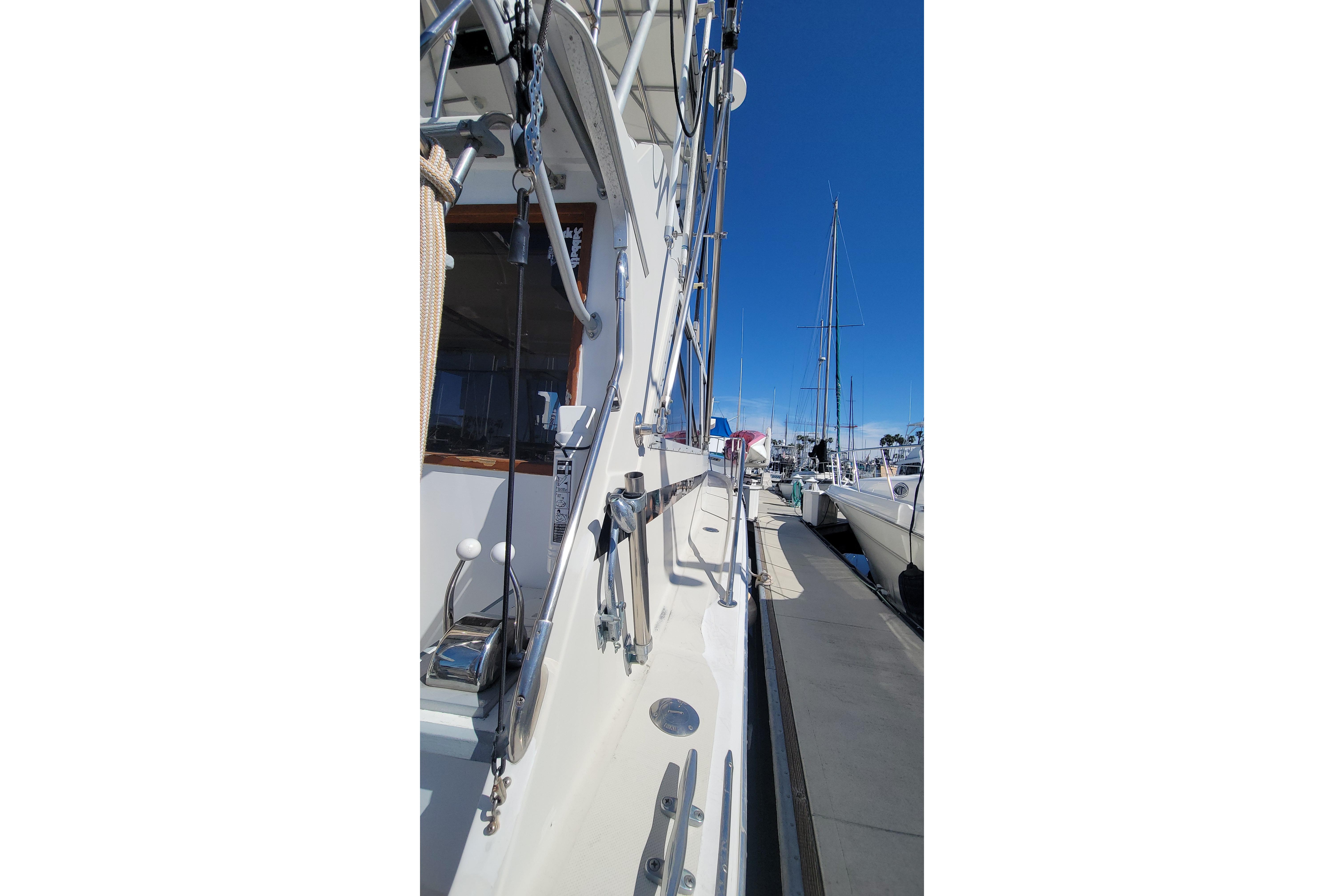 1984 Uniflite 38 Convertible yacht docked, showcasing side view and rigging against clear blue sky.