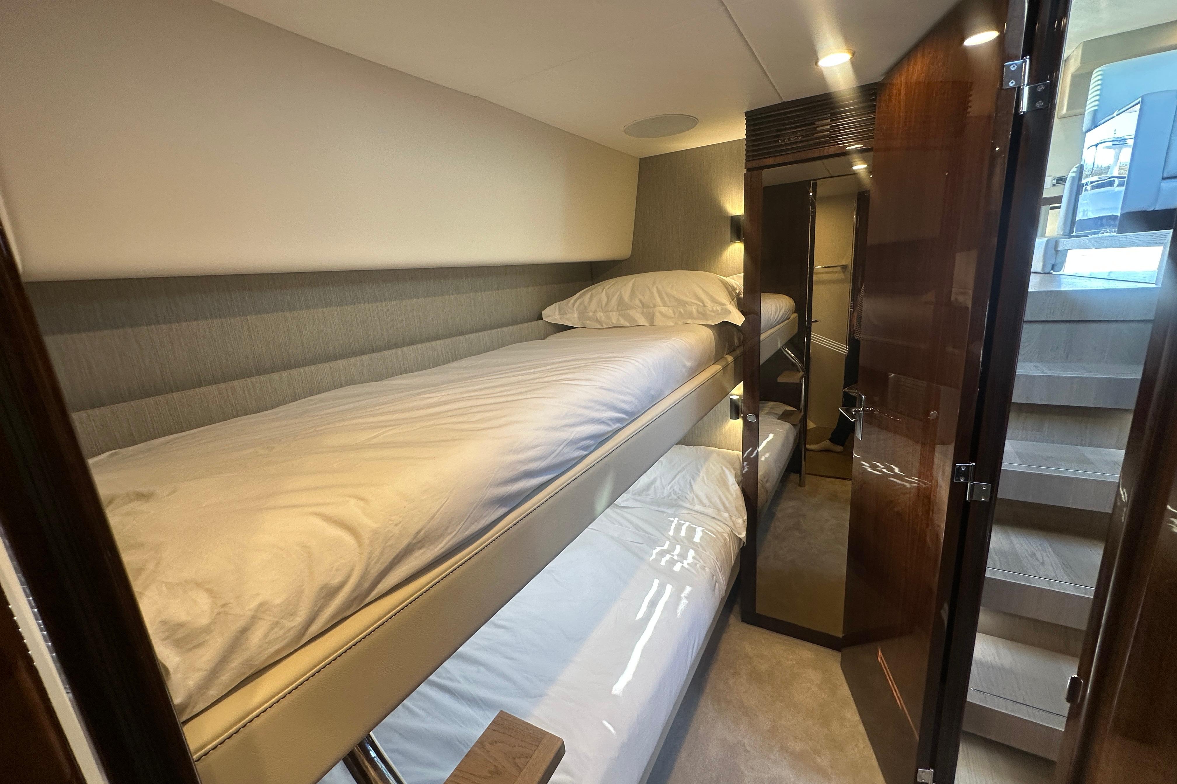 2024 Fairline Squadron 50 yacht interior with cozy bunk beds and elegant wood finishes.