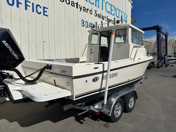 2023 Defiance Admiral 220 EX boat on trailer at marina.