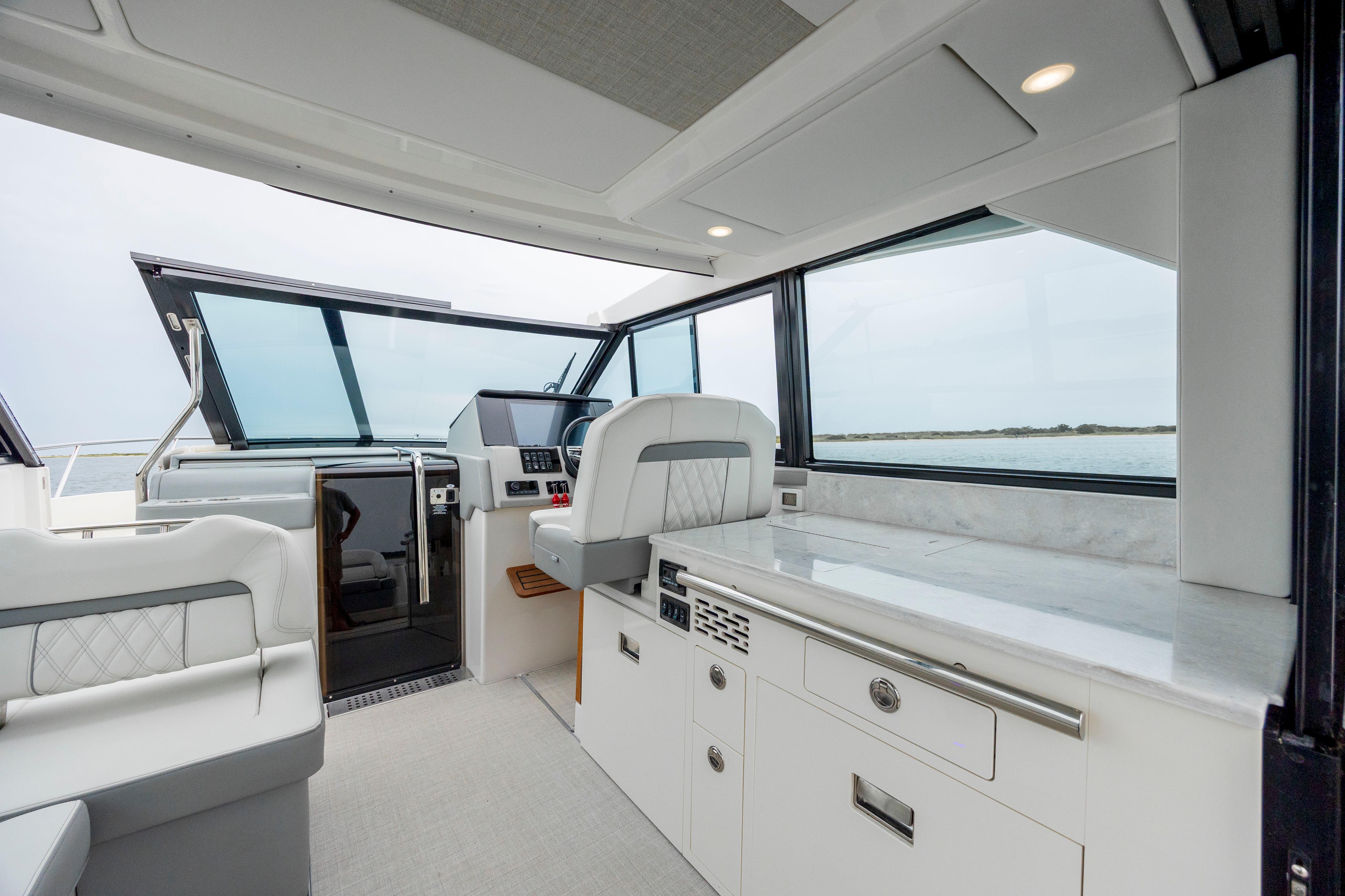 Interior of 2022 Regal 36 Grande Coupe yacht with modern helm and seating.