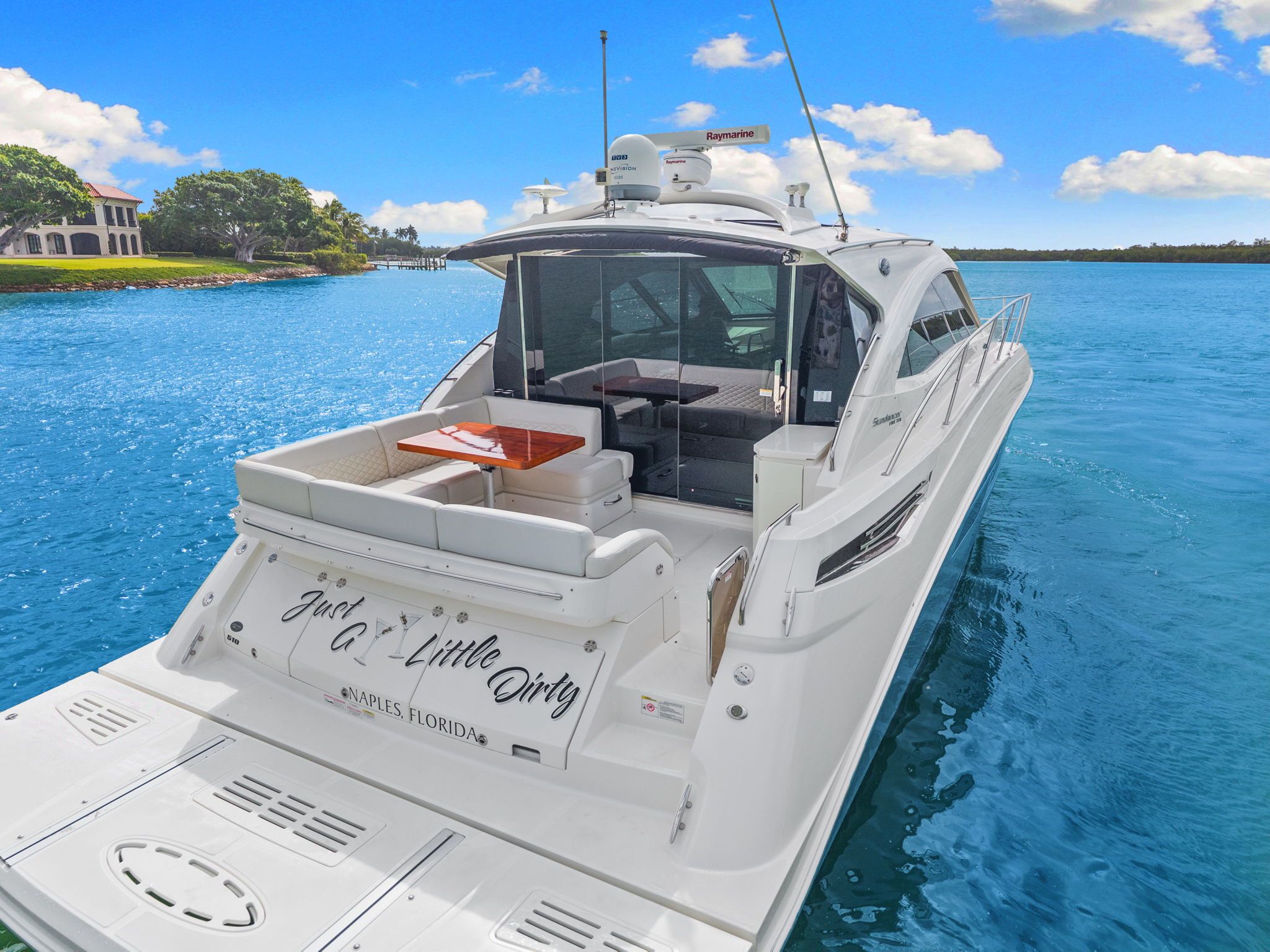 A luxury motor yacht on blue water with a spacious deck and sleek cabin.