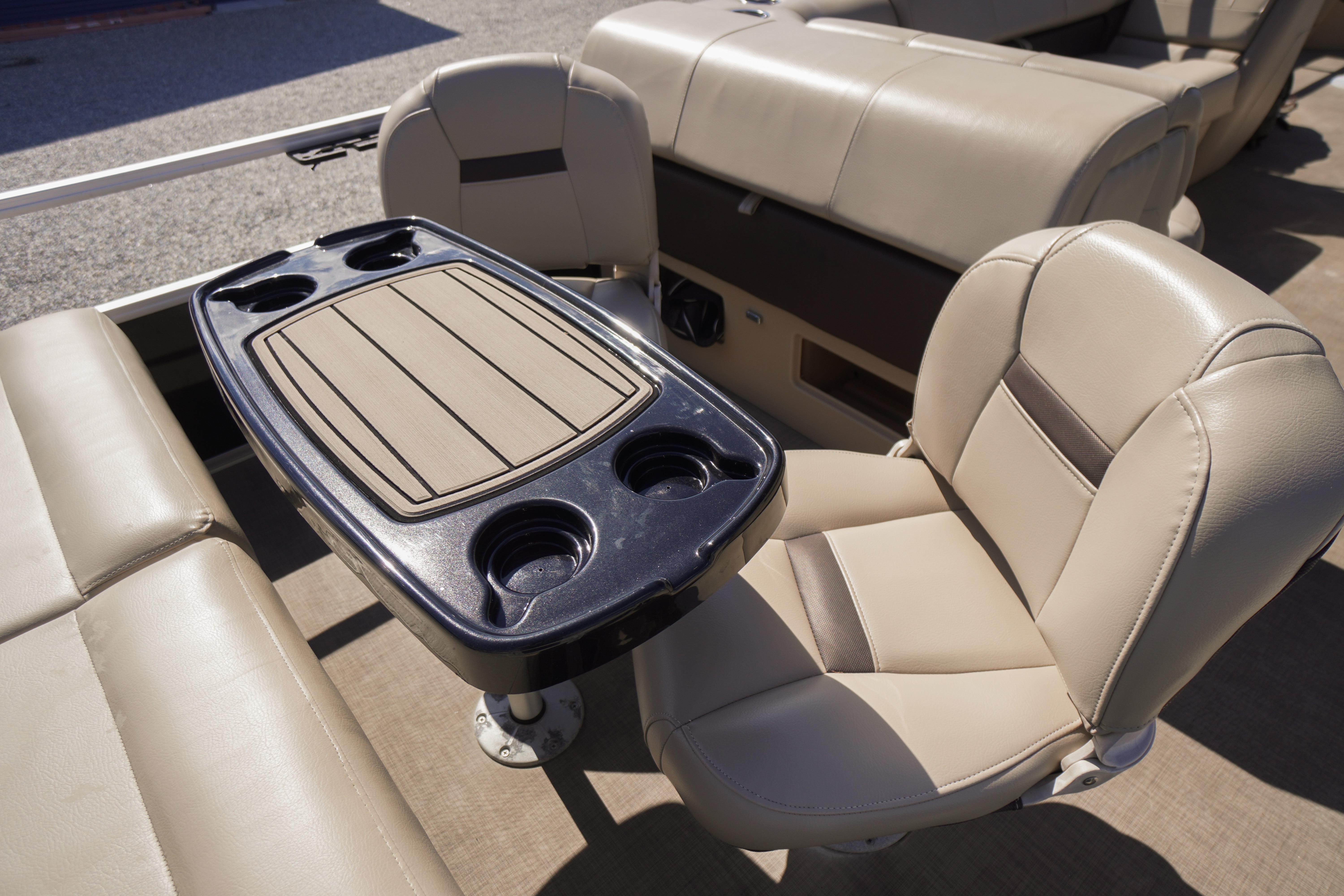 2019 SUNTRACKER Fishin' Barge 22 DLX interior with beige seating and table with cup holders.