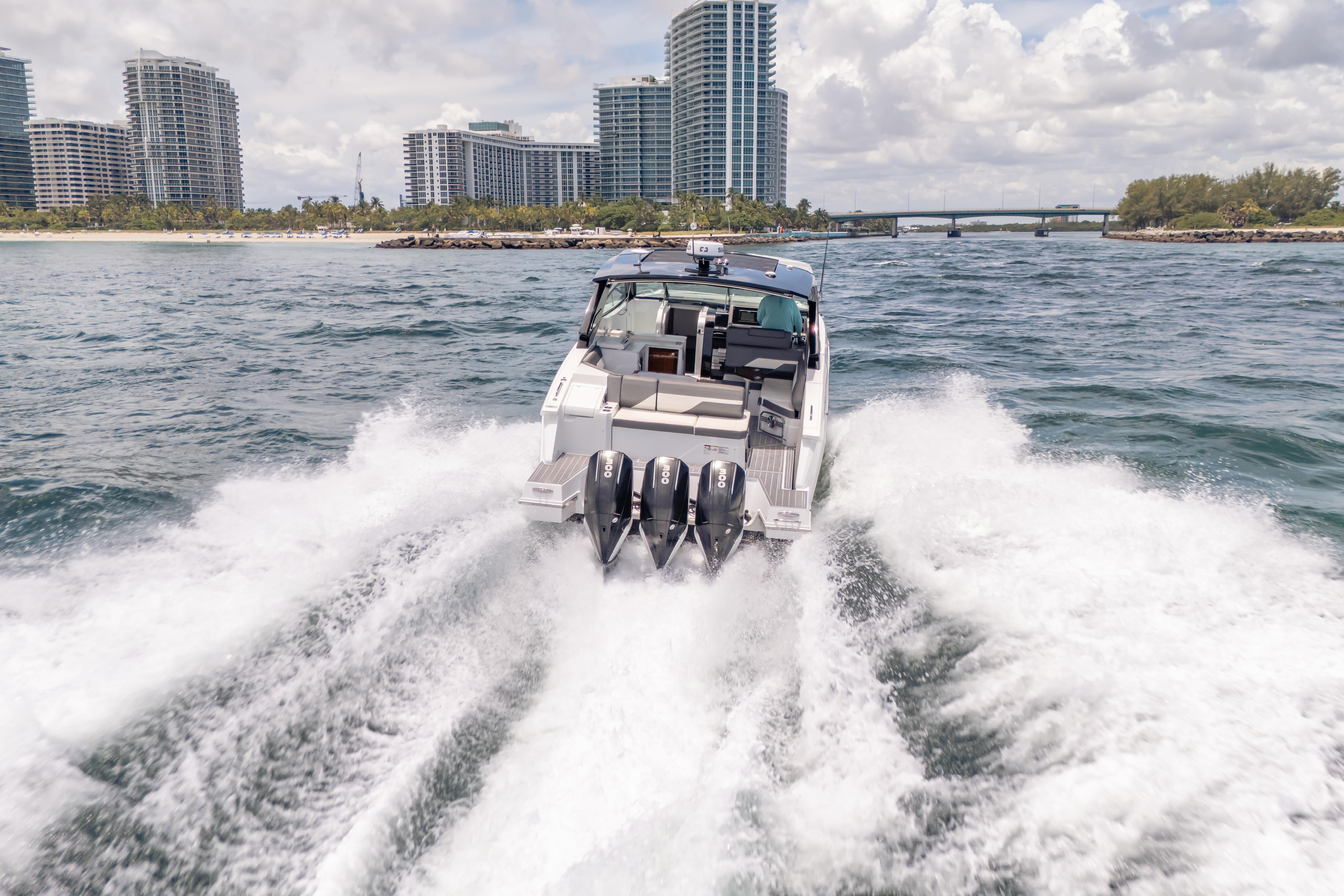 2021 Cruisers Yachts 38 GLS speeding on water near city skyline.