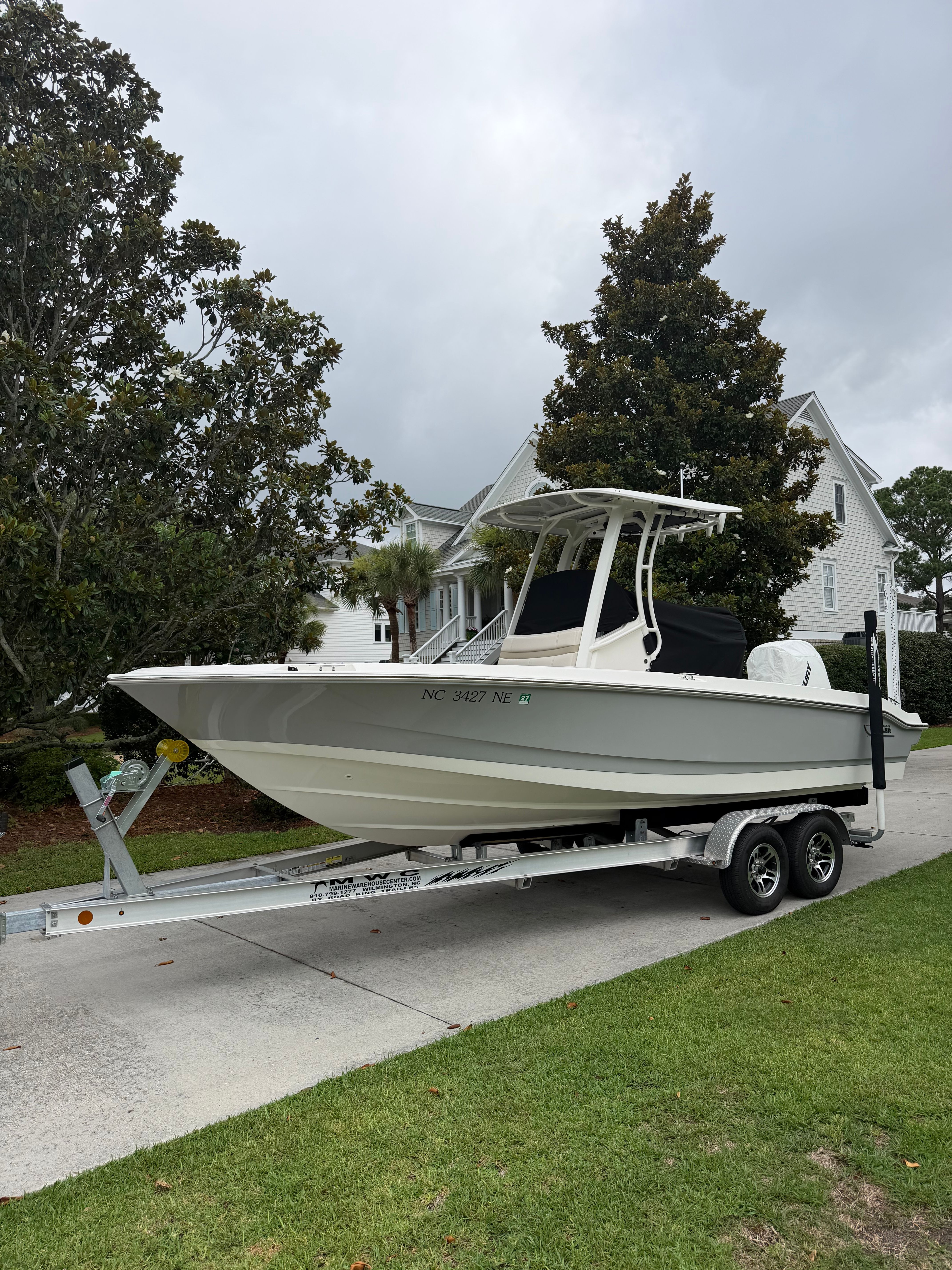 A 2025 Boston Whaler 220 Dauntless on a trailer in a residential area.
