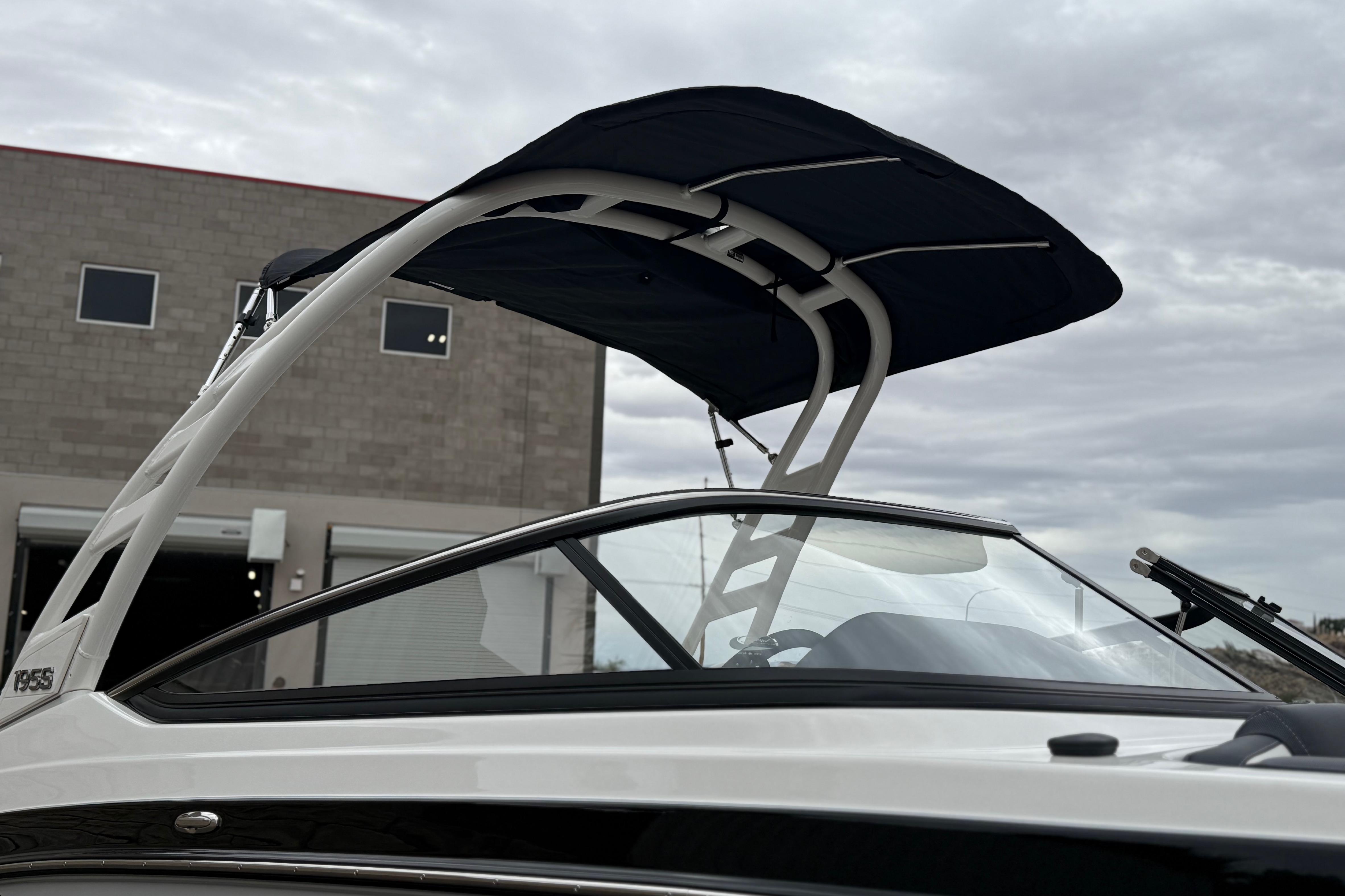 2025 Yamaha Boats 195S with canopy, parked near industrial building under cloudy sky.