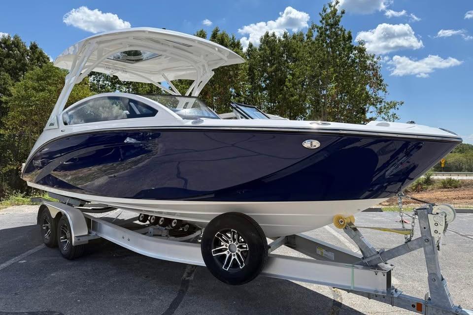 2026 Yamaha Boats 275SD on trailer, sleek design, blue and white finish, parked outdoors.