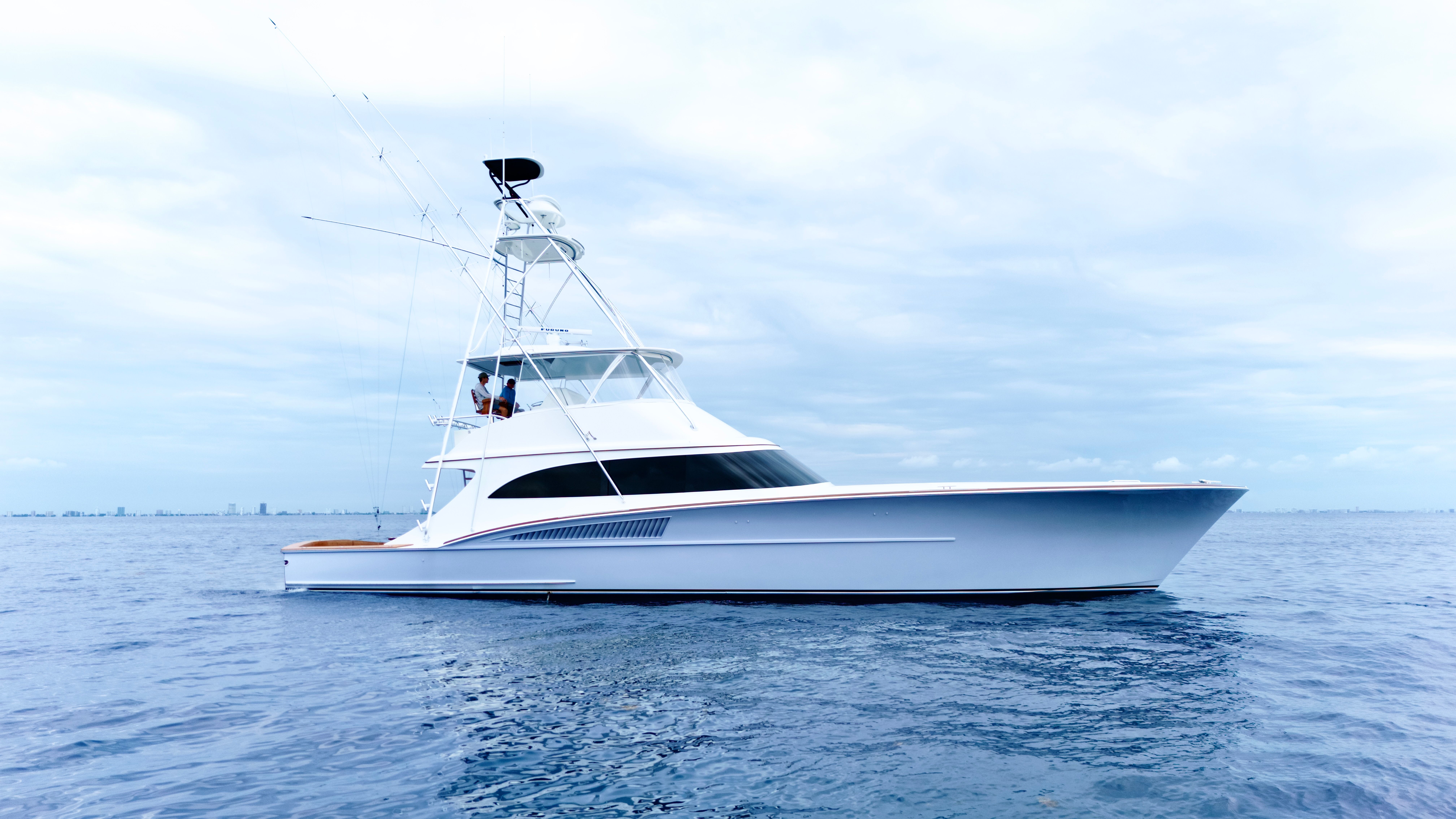 A sleek 2025 Titan Yachts sportfish boat on calm water.