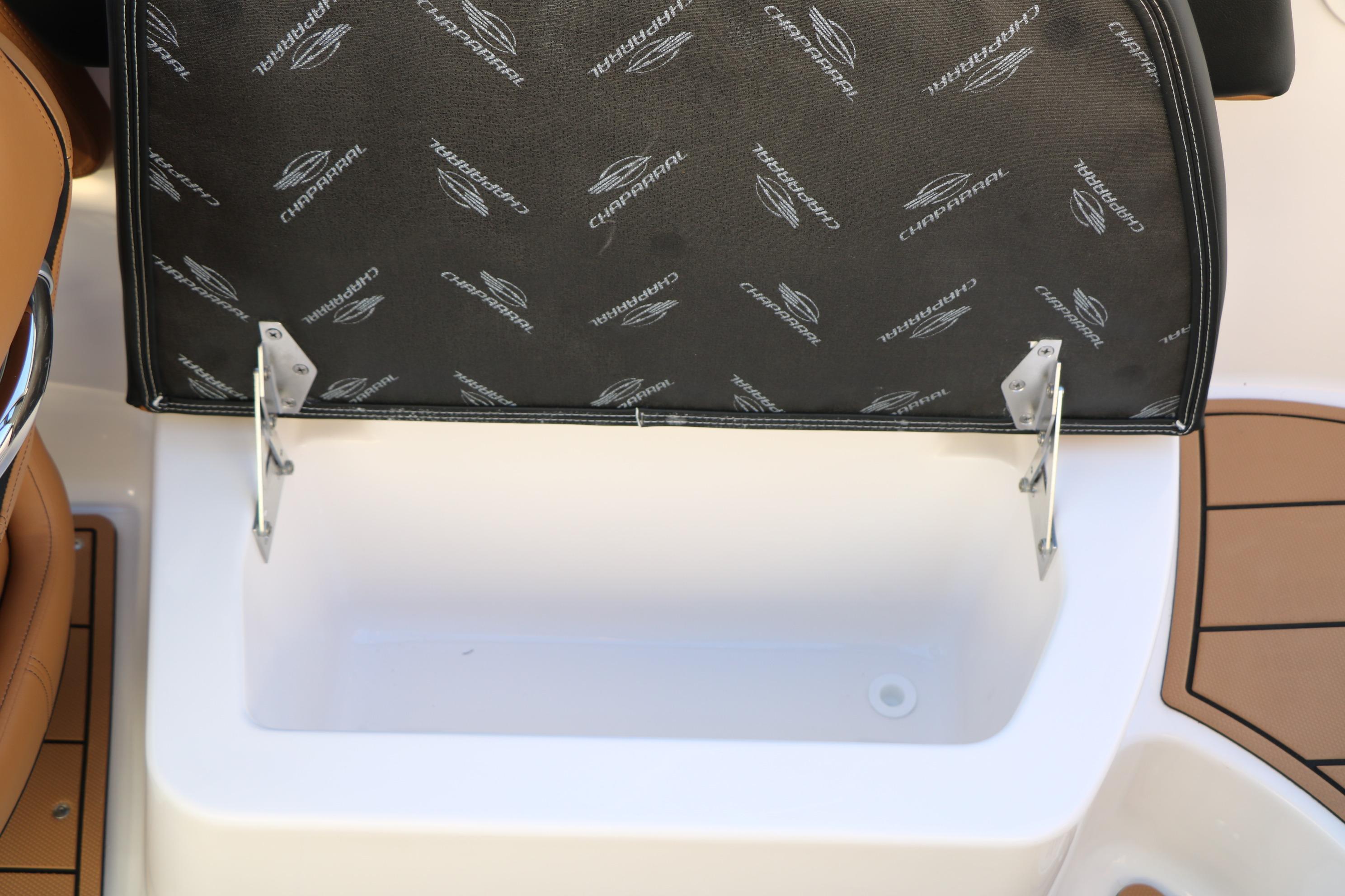 2026 Chaparral 247 SSX boat storage compartment with branded cover and brown seating.