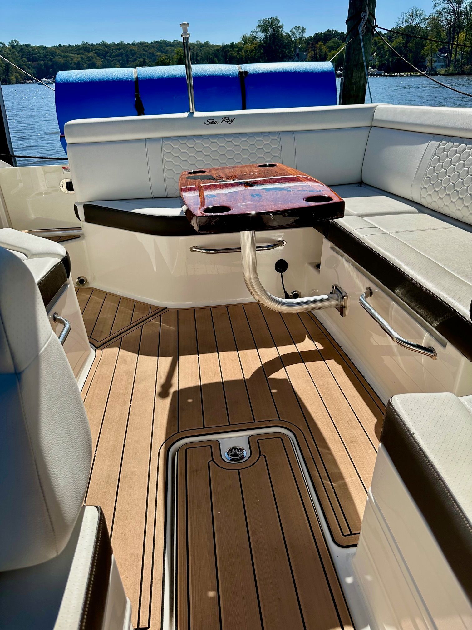 The image shows the cockpit of a 2018 Sea Ray SDX 270 Outboard with wood flooring and white upholstery.