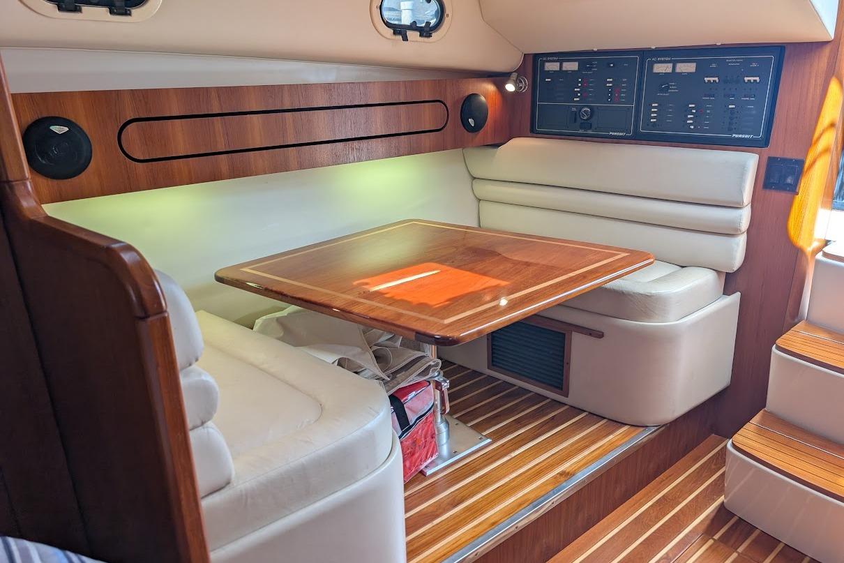 Interior of a 2000 Pursuit 3400 Express boat with wood accents and seating area.