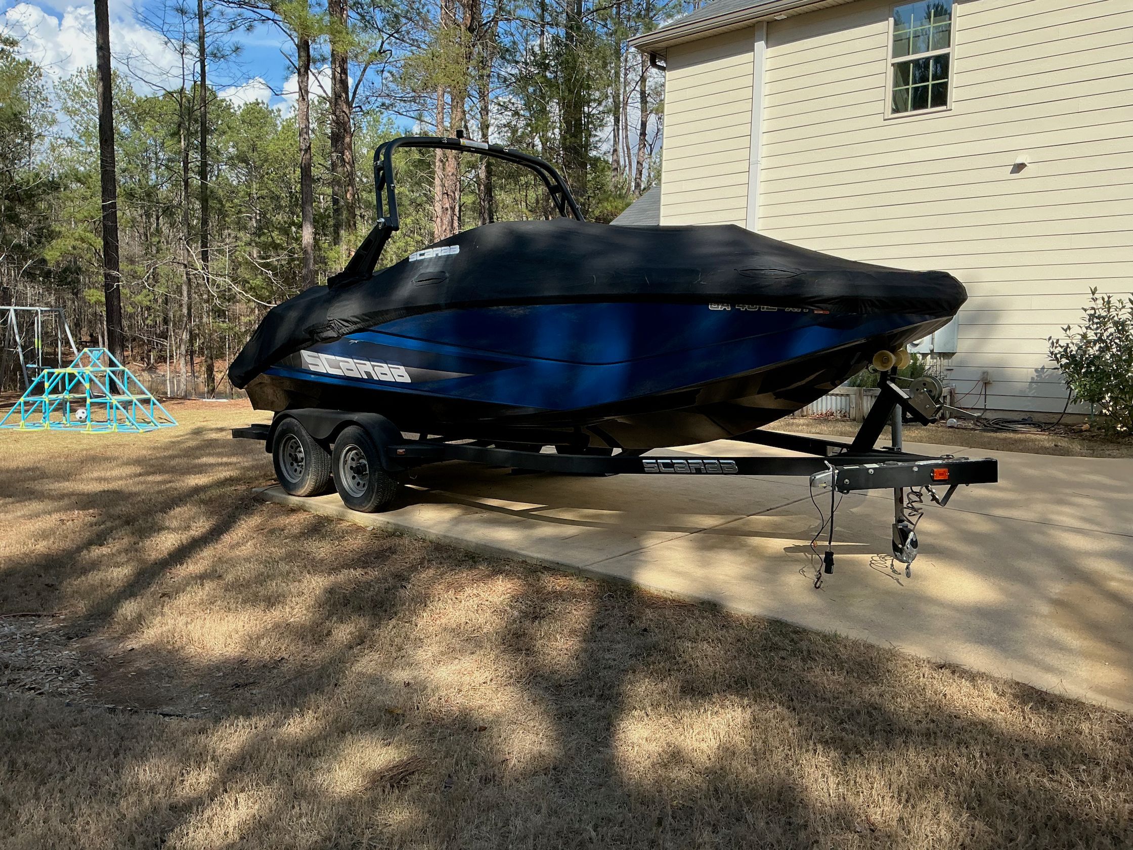 2021 Scarab 215 ID boat on trailer in backyard.