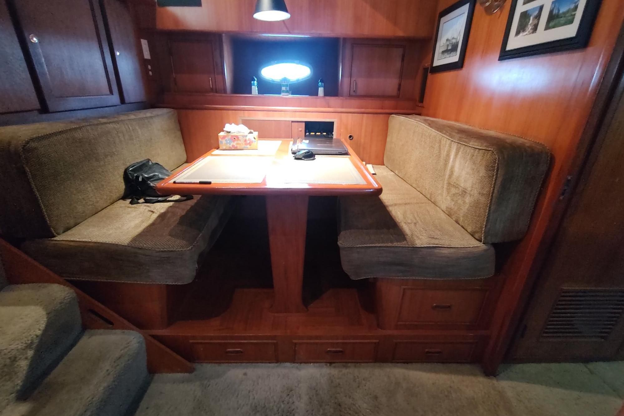 Cozy dining area in 1989 Hyatt Double Cabin Motoryacht with wooden interior and cushioned seating.