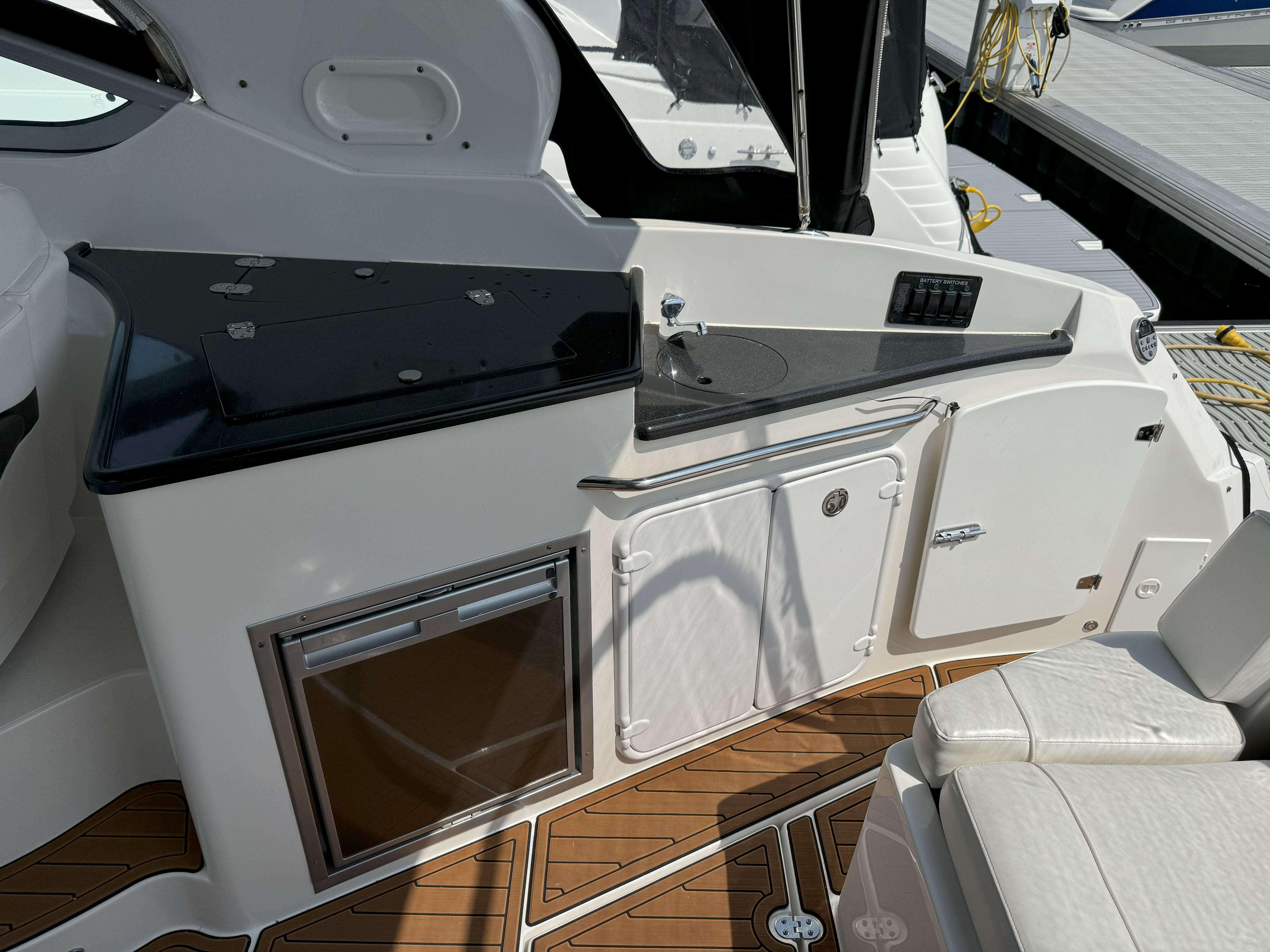 2010 Rinker 310 Express Cruiser with outdoor kitchenette and wood deck.