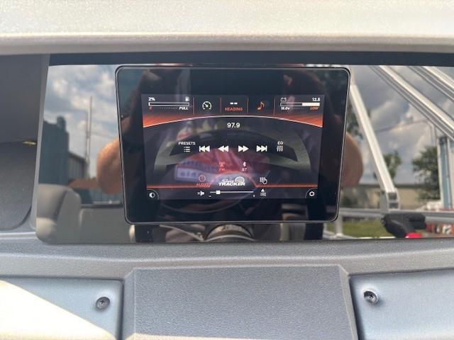 2026 Sun Tracker Fishin' Barge 20 DLX dashboard with digital display showing audio controls.