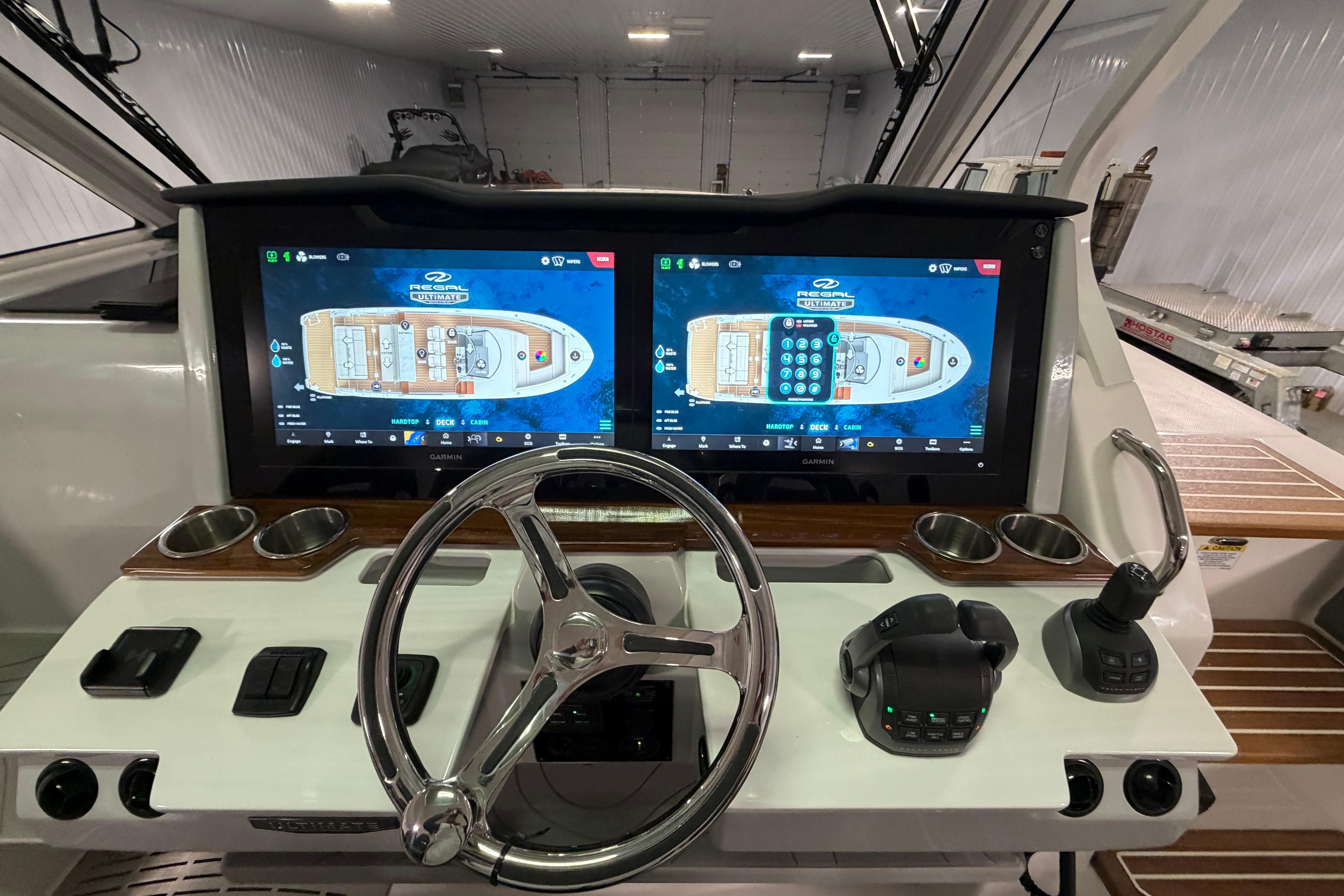 Cockpit of 2027 Regal 38 Surf boat with dual navigation screens and controls.