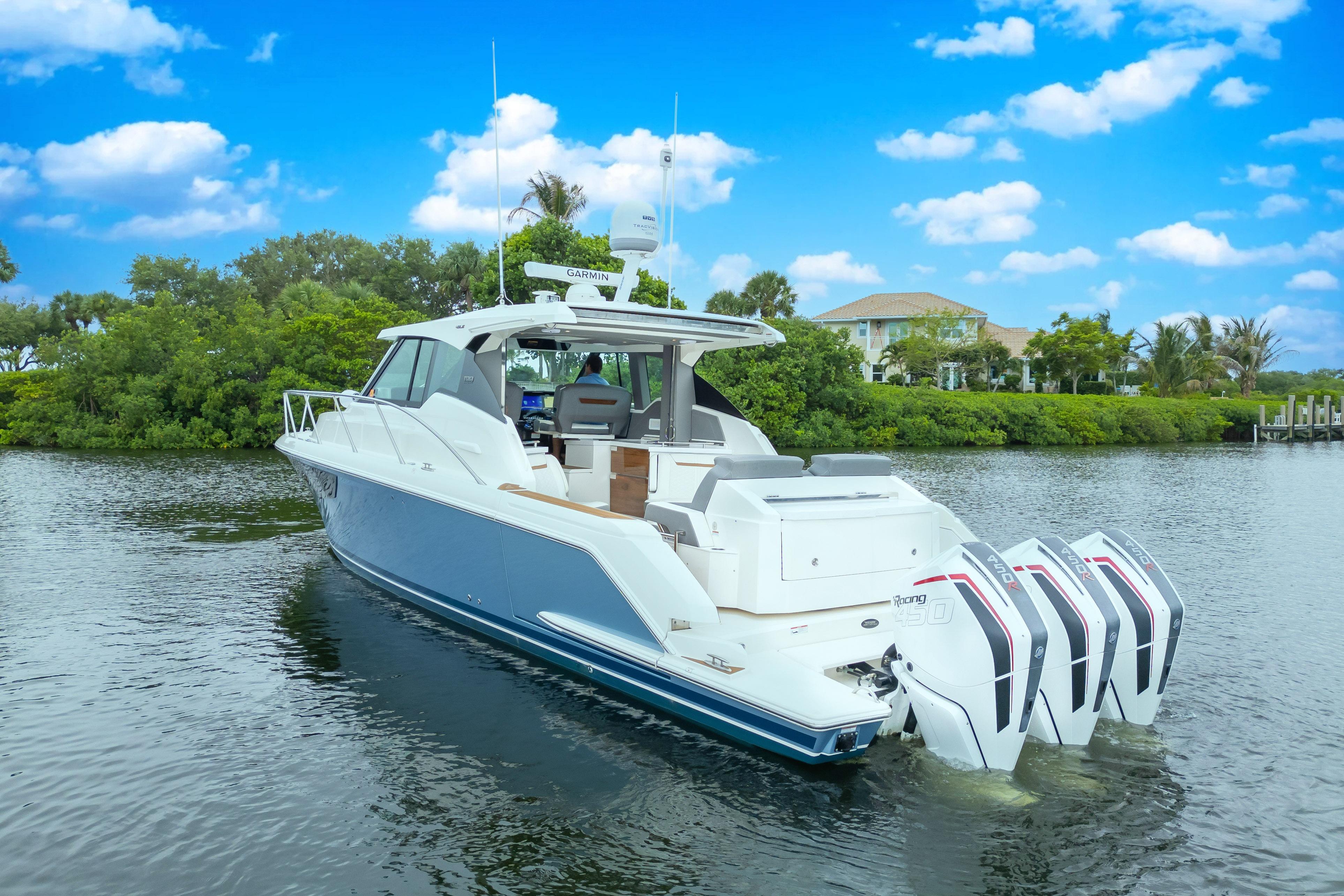 2021 Tiara Sport 43 LE boat with triple outboard engines on a serene waterway.
