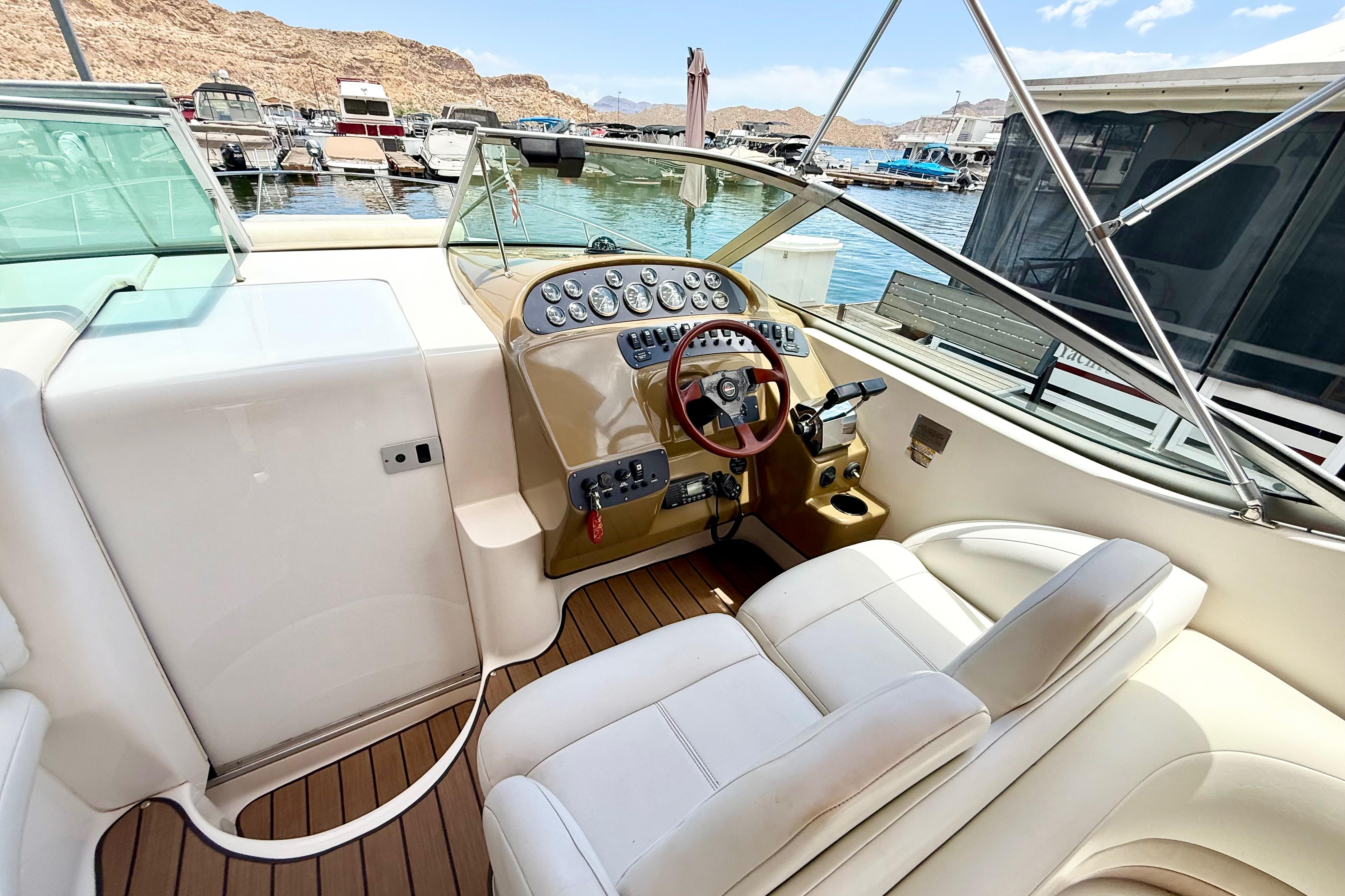 1999 Chaparral Signature 300 boat cockpit with steering wheel, gauges, and marina view.