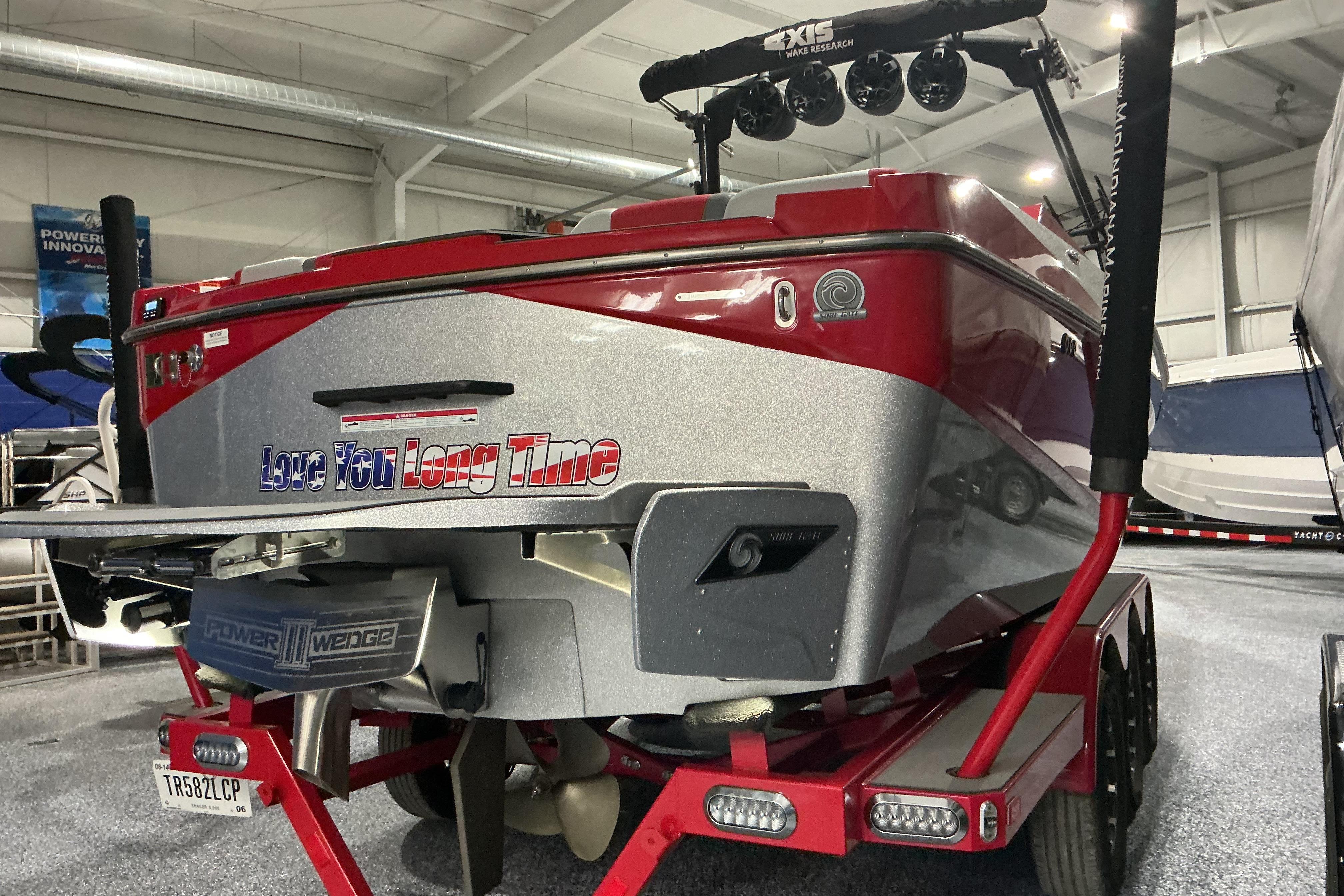 2022 Axis T250 boat in showroom, red and silver design, with "Love You Long Time" text.