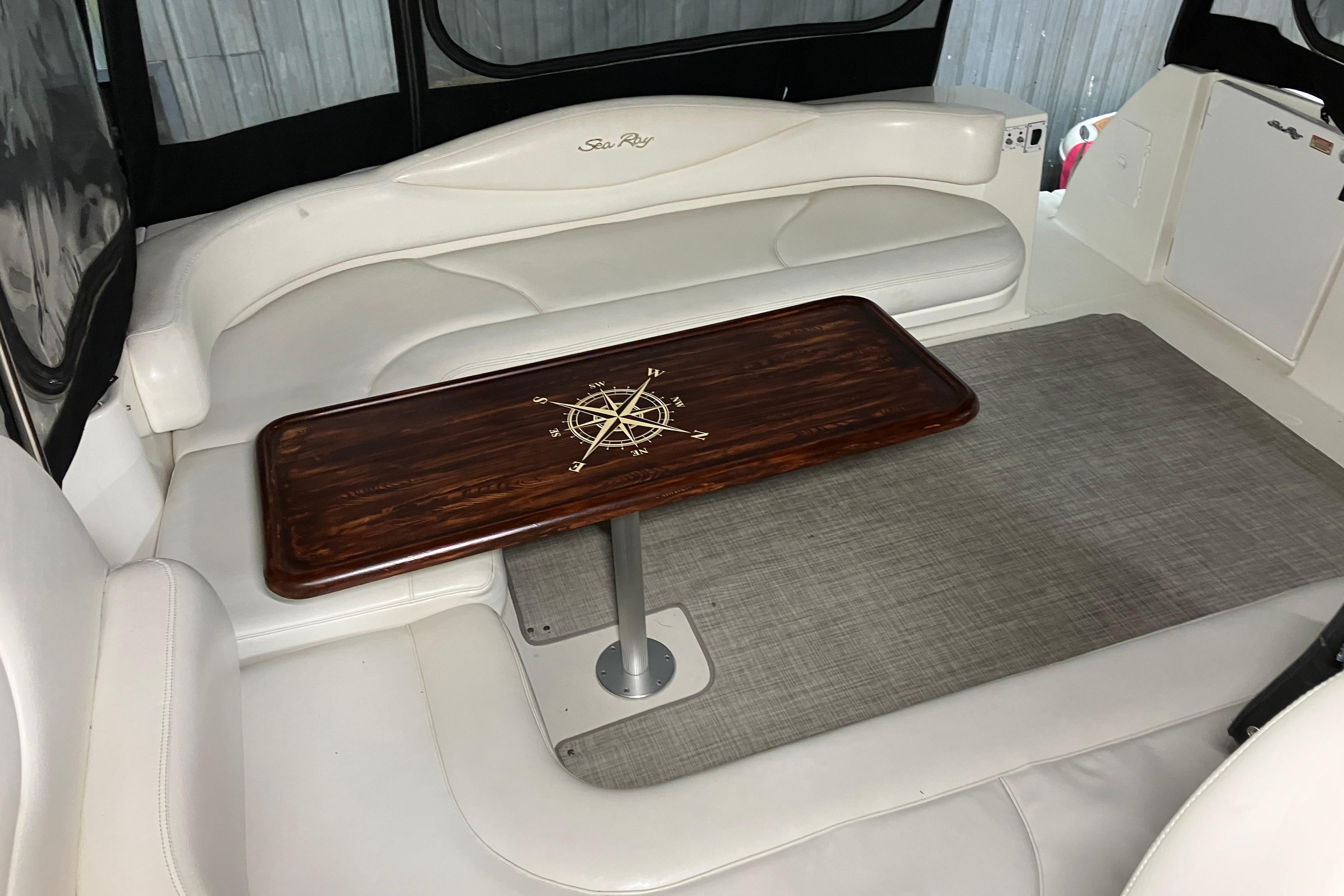 Luxurious interior of 2002 Sea Ray 410 Sundancer with elegant wood table and plush seating.