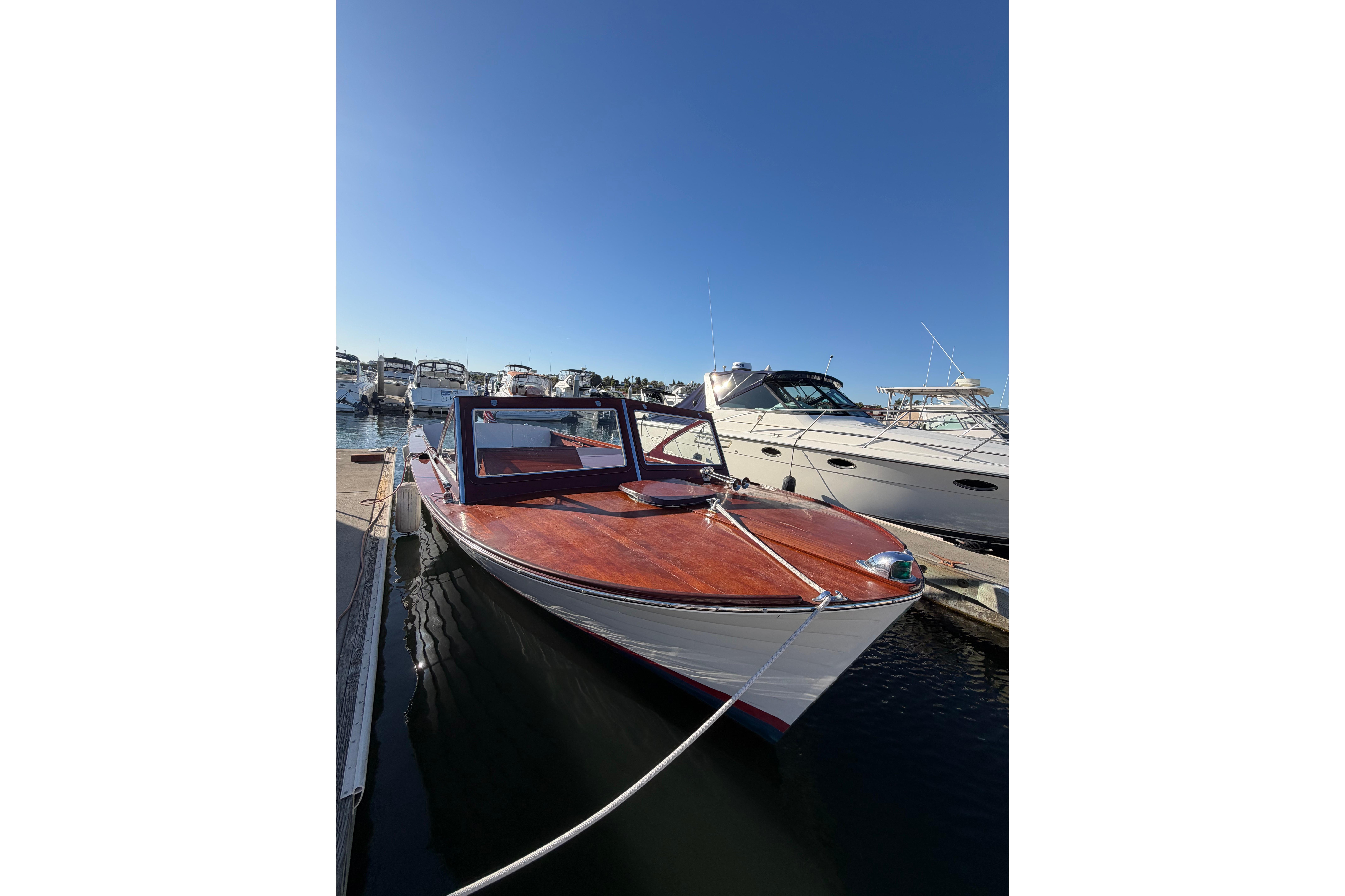 1964 Lyman 25 Sleeper boat docked at marina under clear blue sky.
