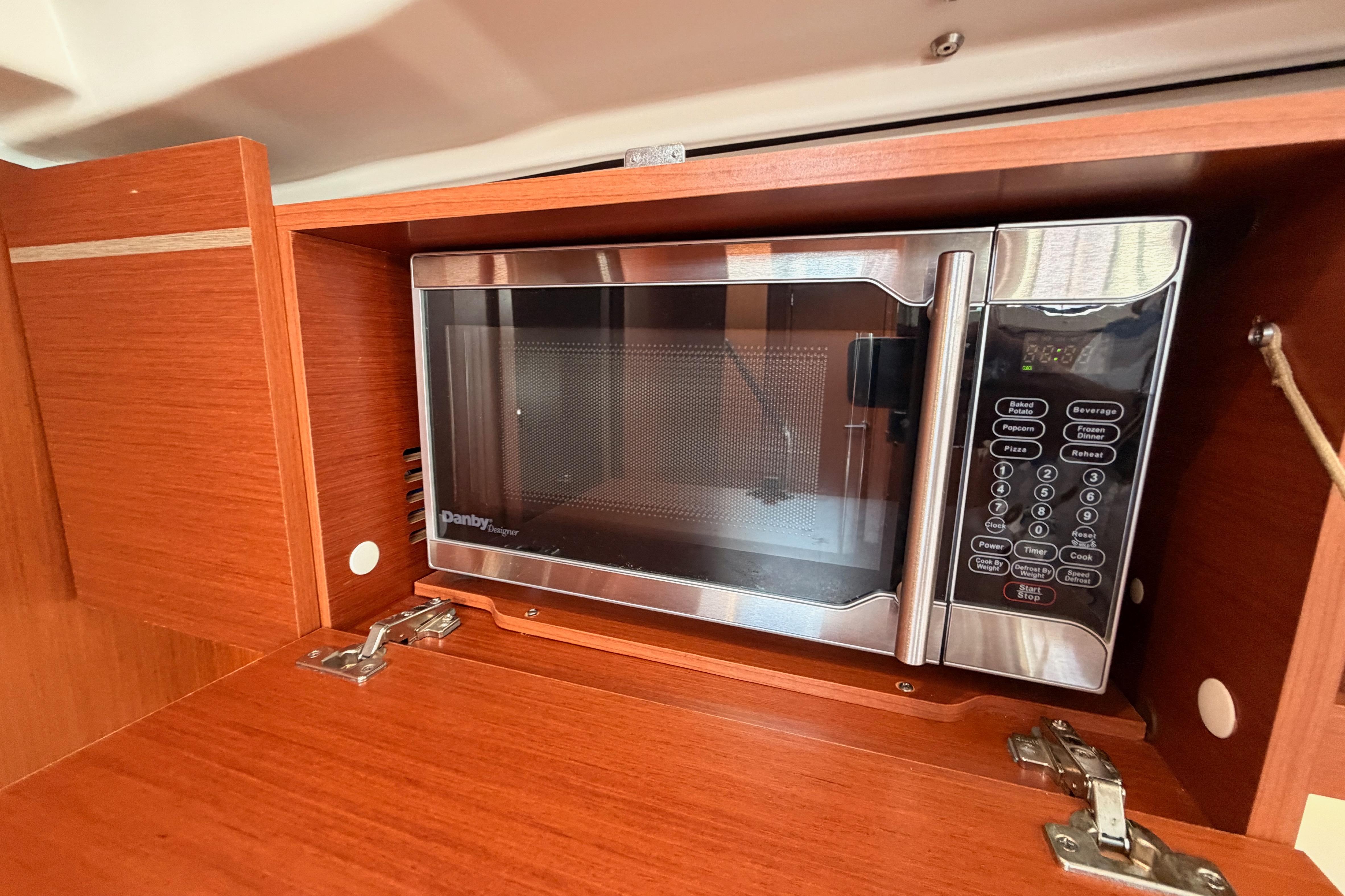 Microwave in 2020 Beneteau Oceanis 46.1 yacht's wooden cabinet interior.