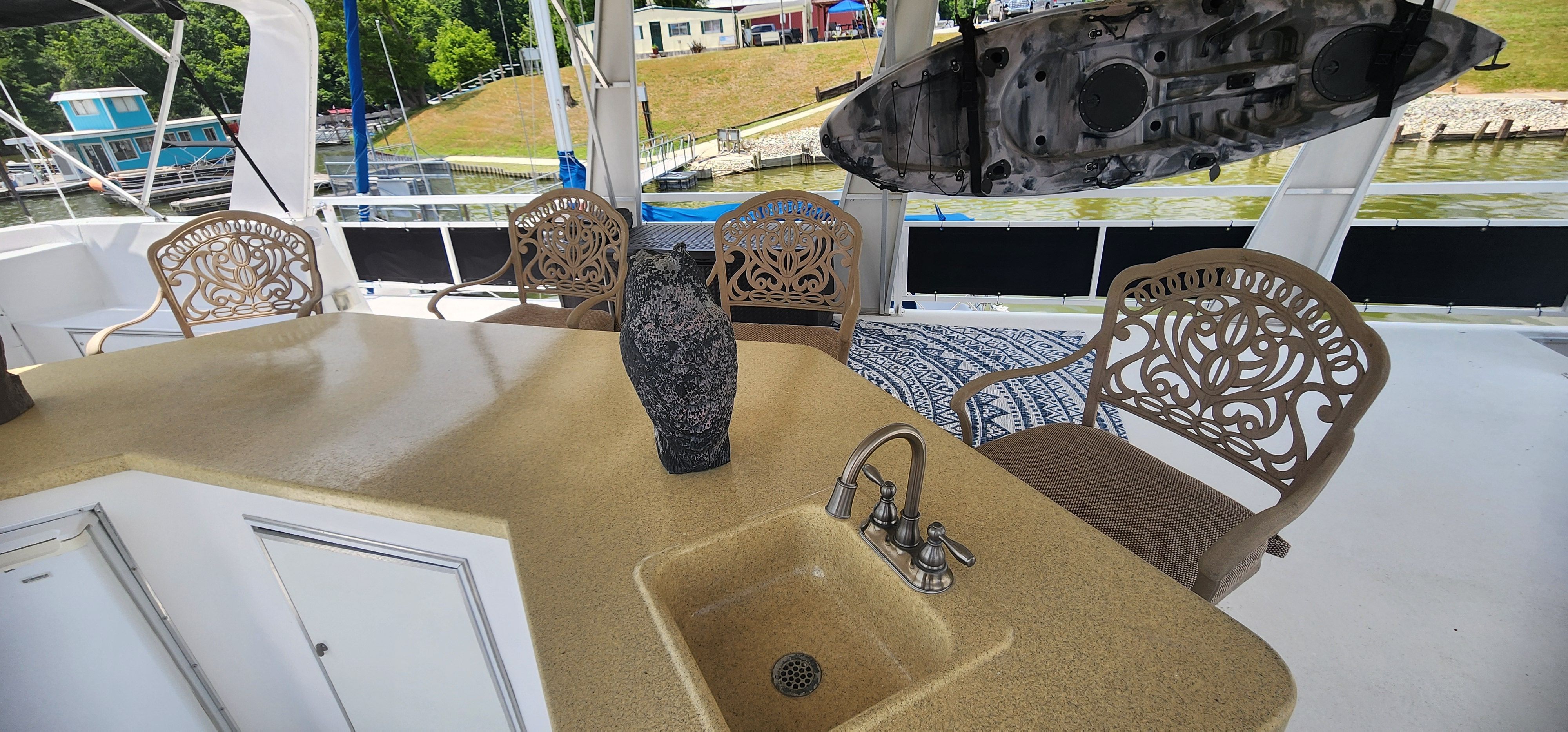 The image shows a yacht deck with a sink and decorative chairs.