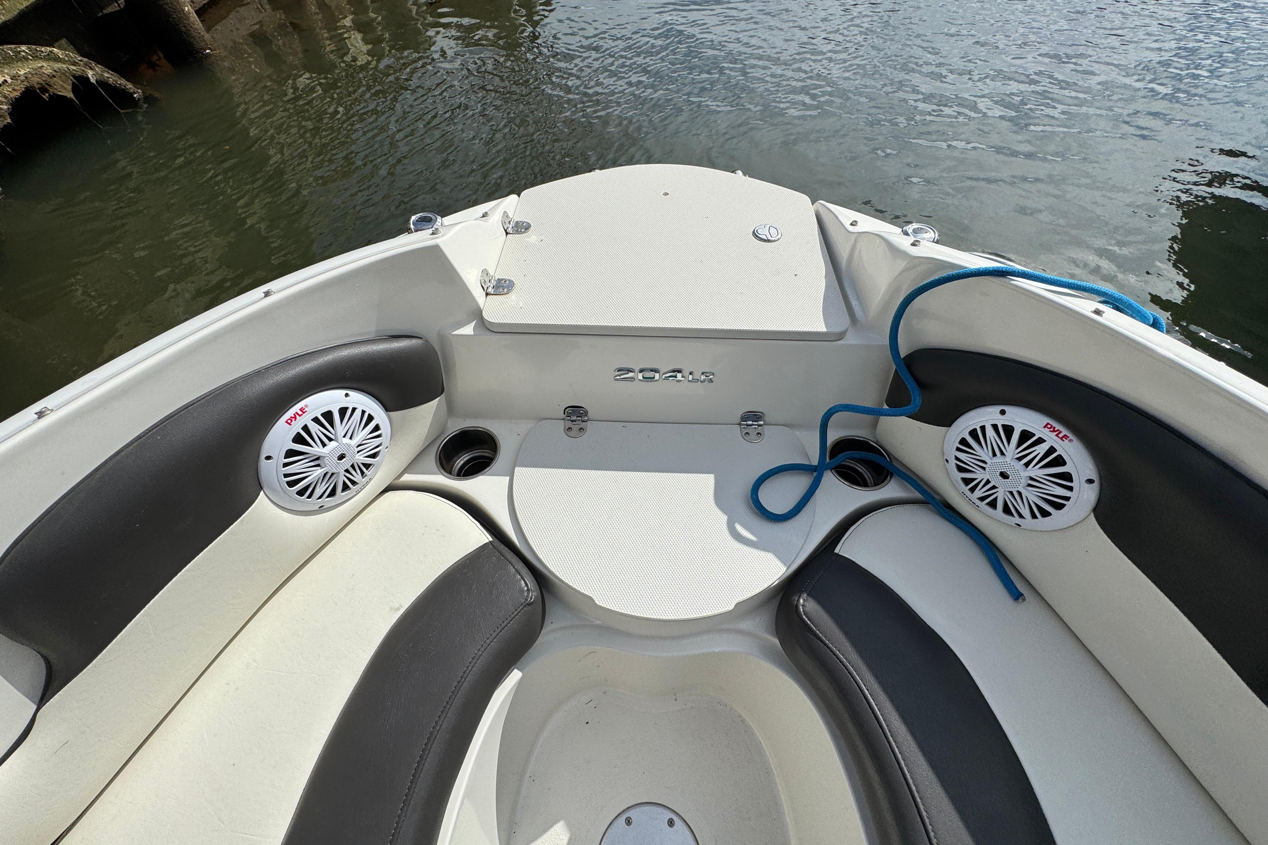 2019 Stingray 204 LR boat interior with speakers and seating by the water.