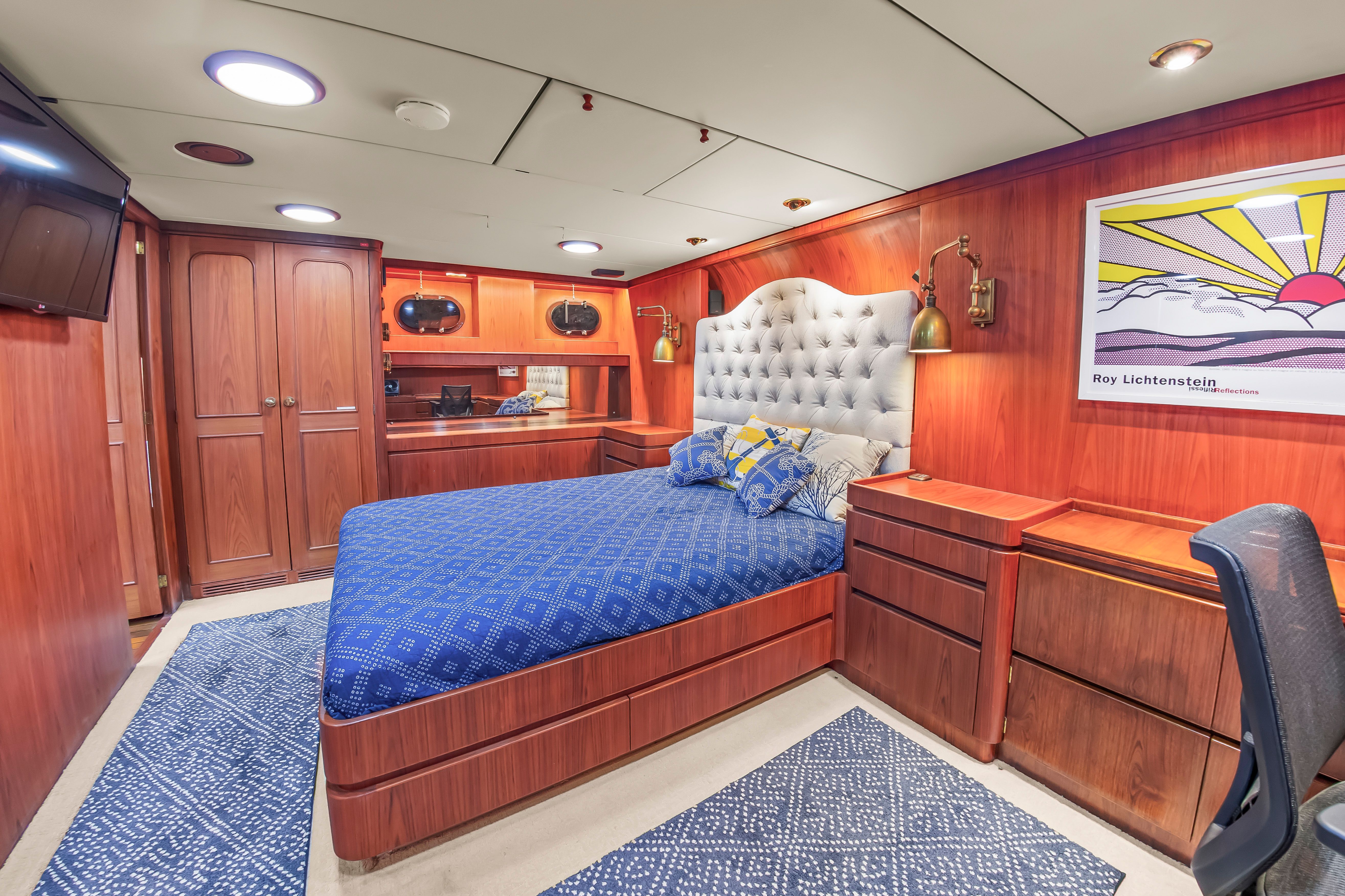 Luxurious cabin with wood paneling, a large bed, and artwork on the wall.