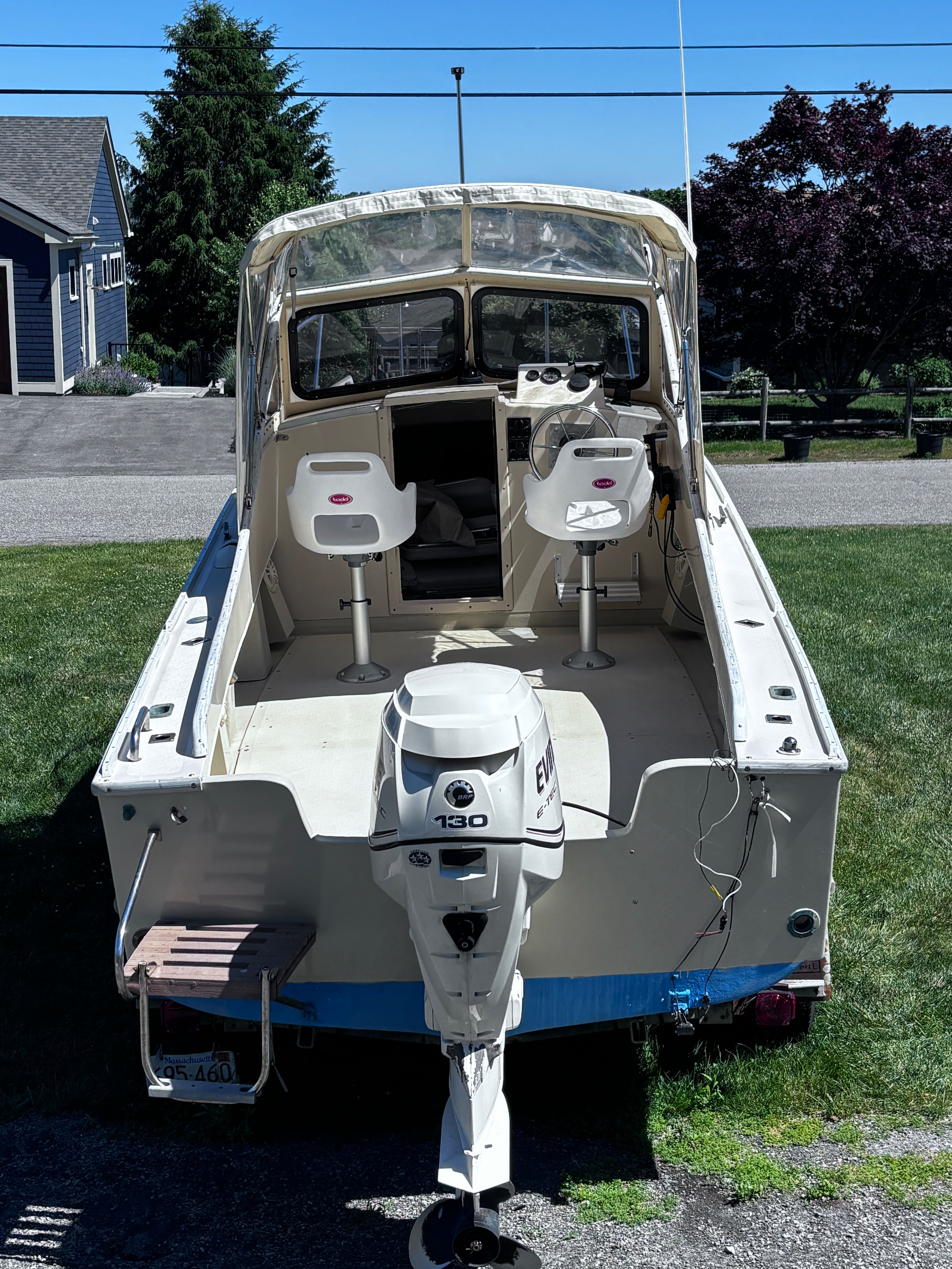 A 1984 SISU 22’ Bass boat with two seats and an Evinrude 130 outboard motor.