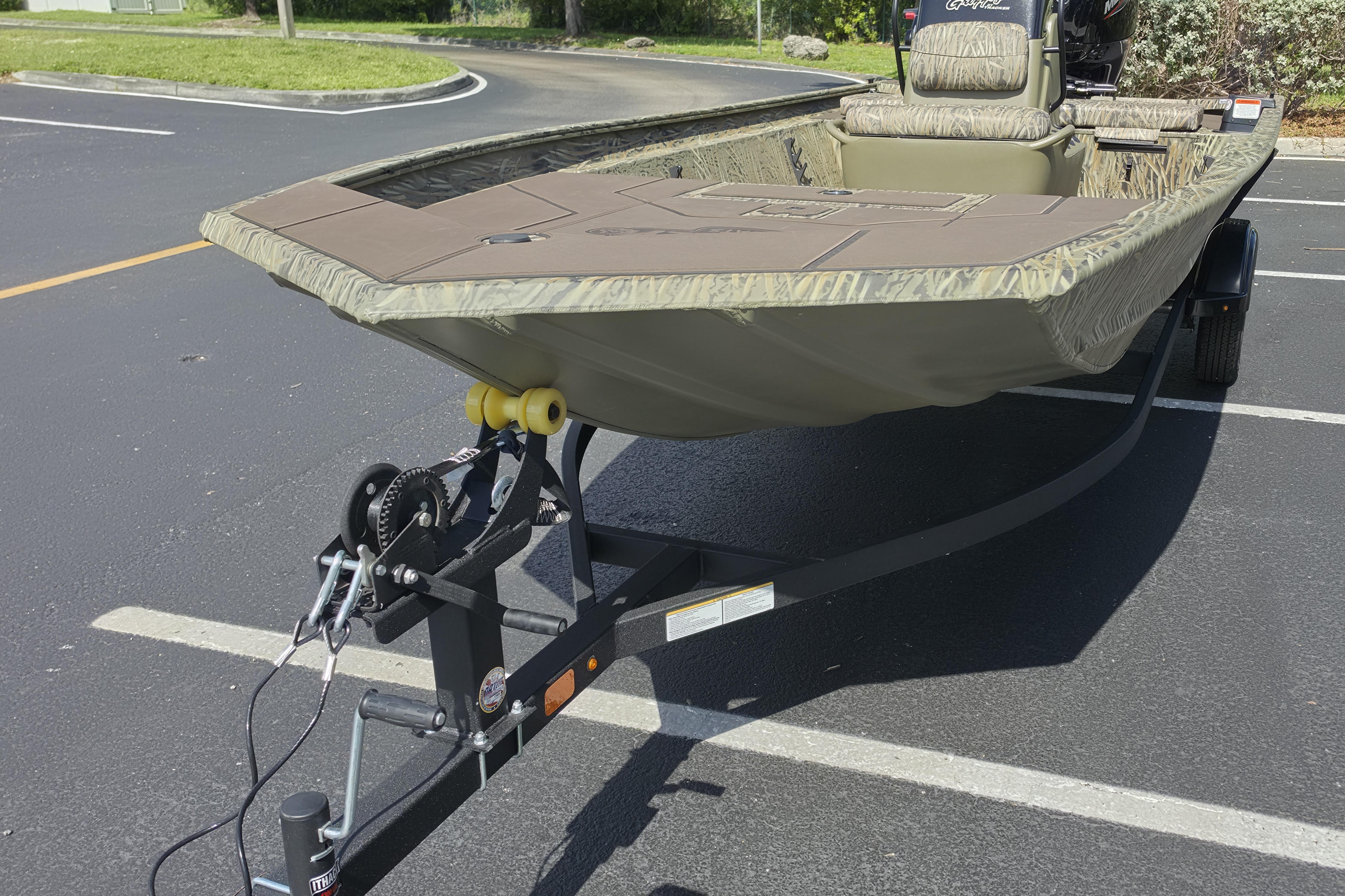 2026 Tracker Grizzly 1860 CC boat on trailer in parking lot.