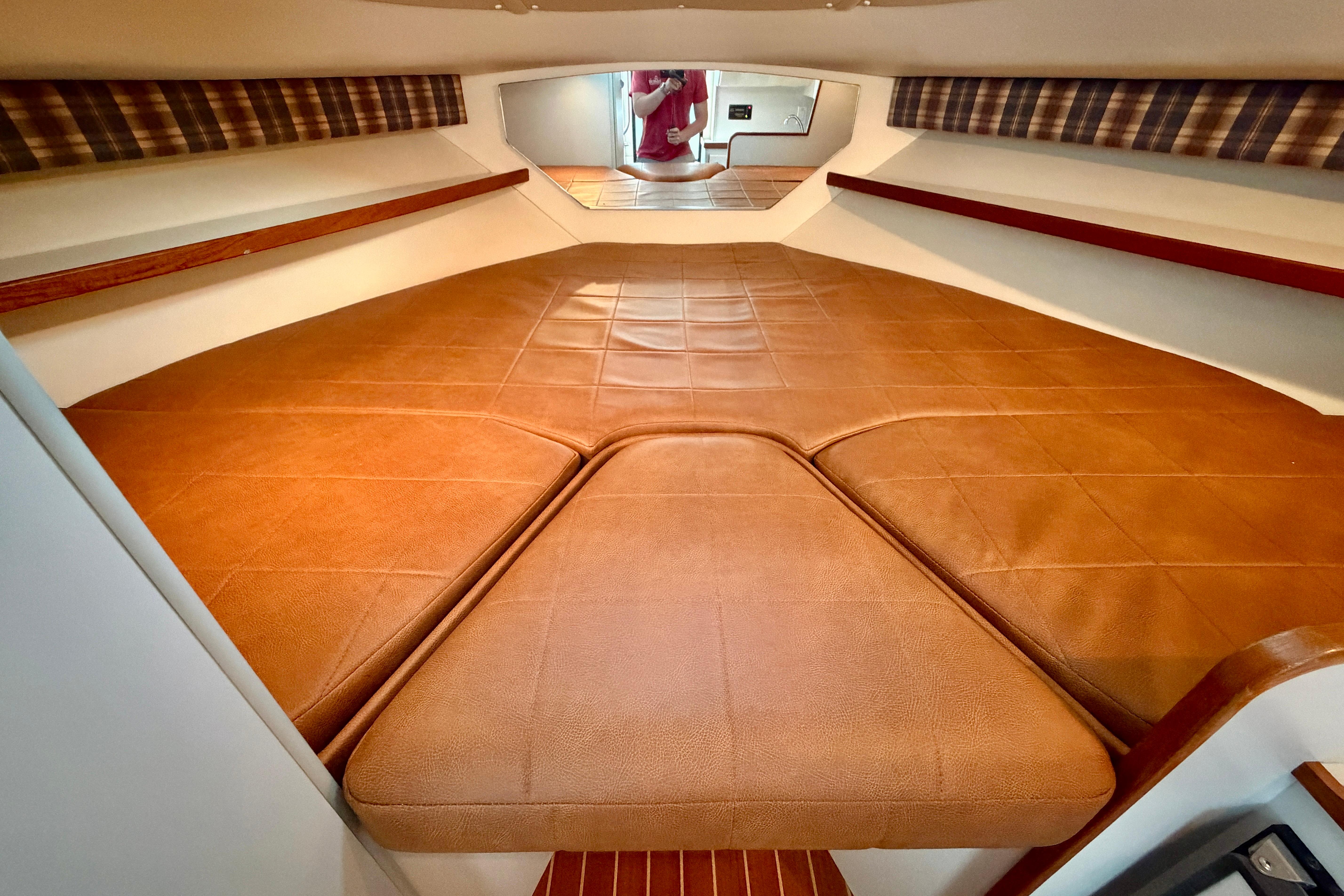 1999 Tiara Yachts 2900 Coronet cabin interior with brown cushioned seating and plaid accents.