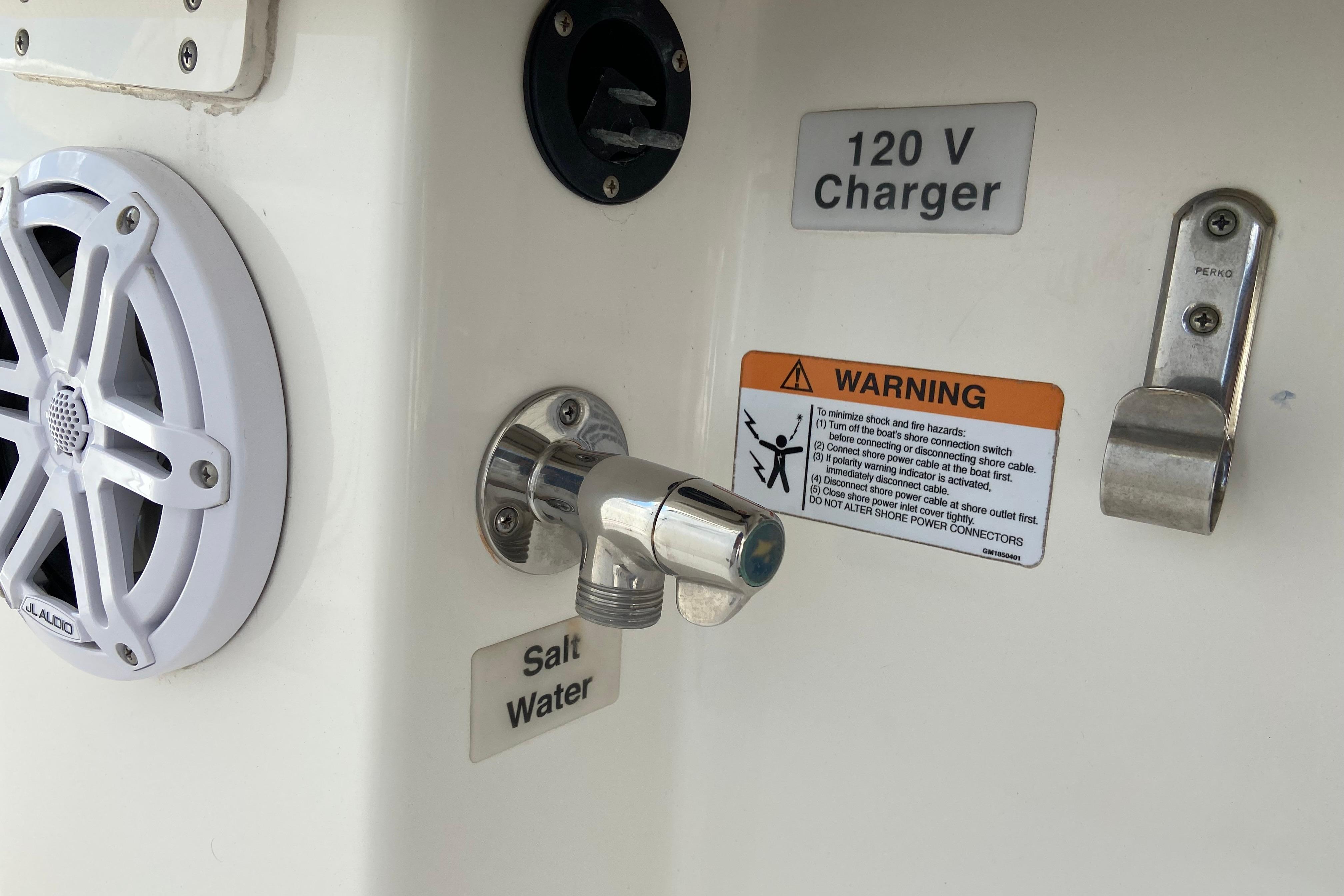2021 Regulator 28 boat features: JL Audio speaker, 120V charger, saltwater faucet, and safety warning.