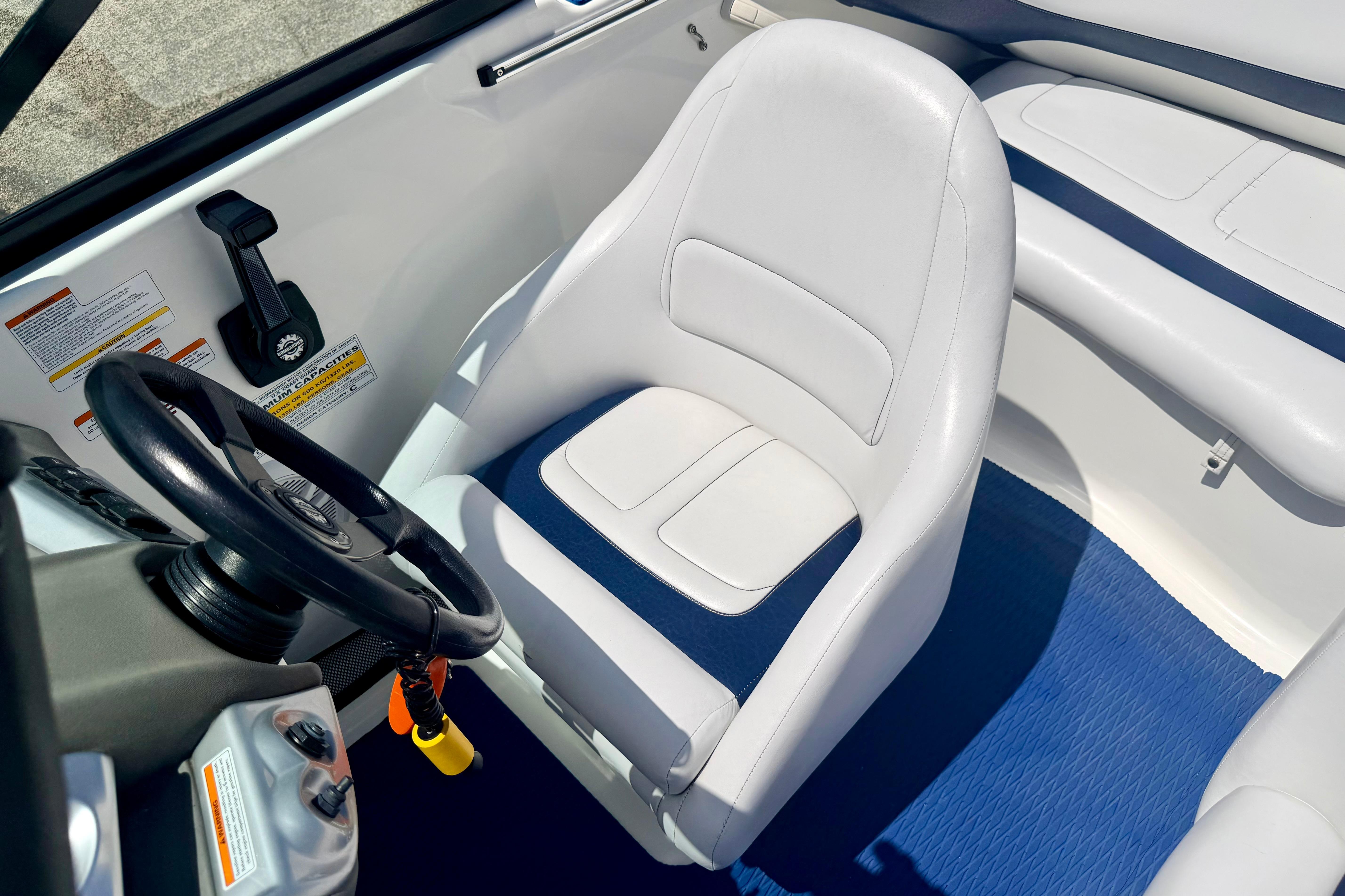 Interior of a 2004 Bombardier SEADOO Utopia 185 boat with white seating and steering wheel.