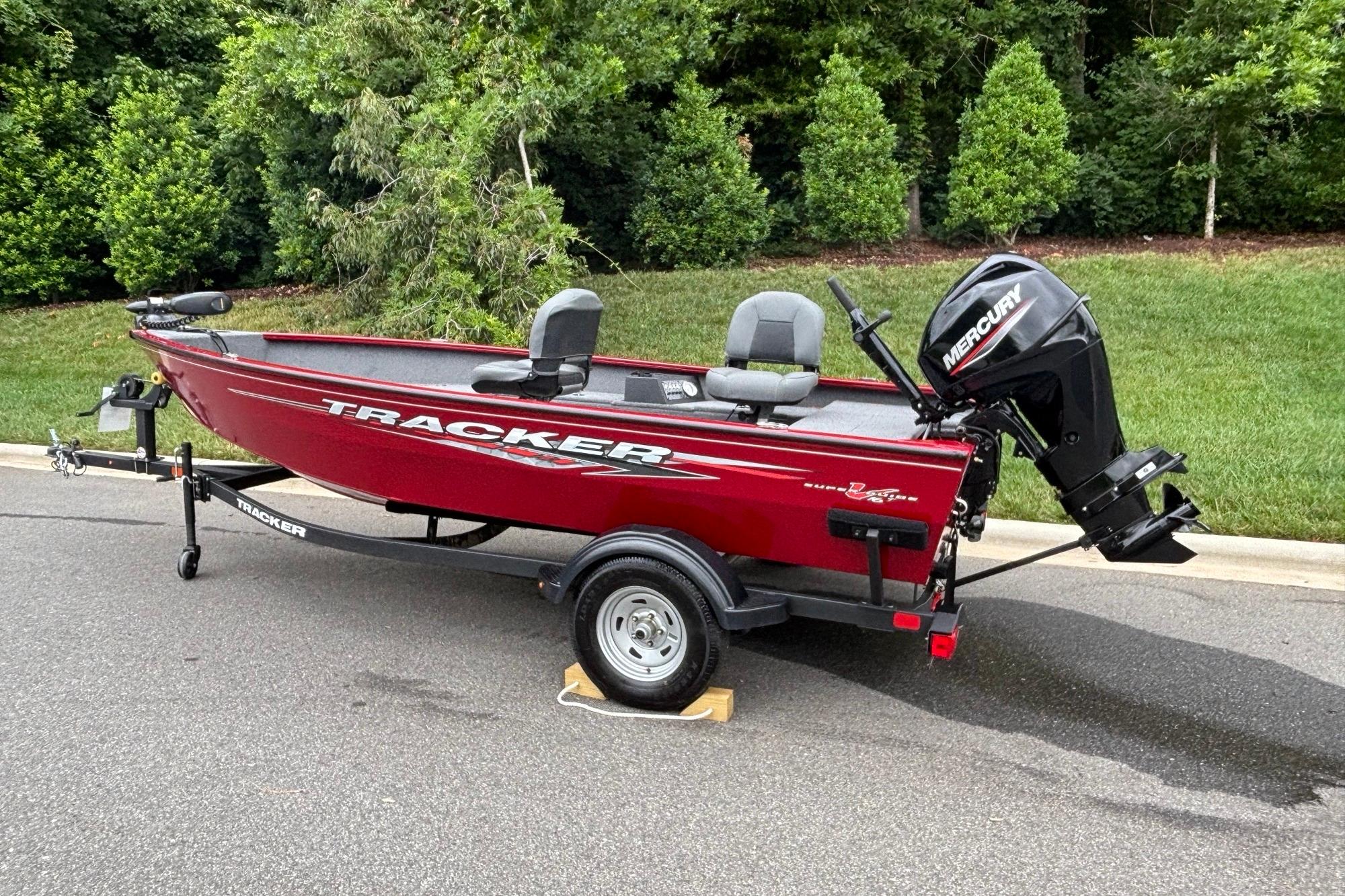 2025 Tracker Super Guide V-16 T boat with Mercury engine on trailer, parked outdoors.