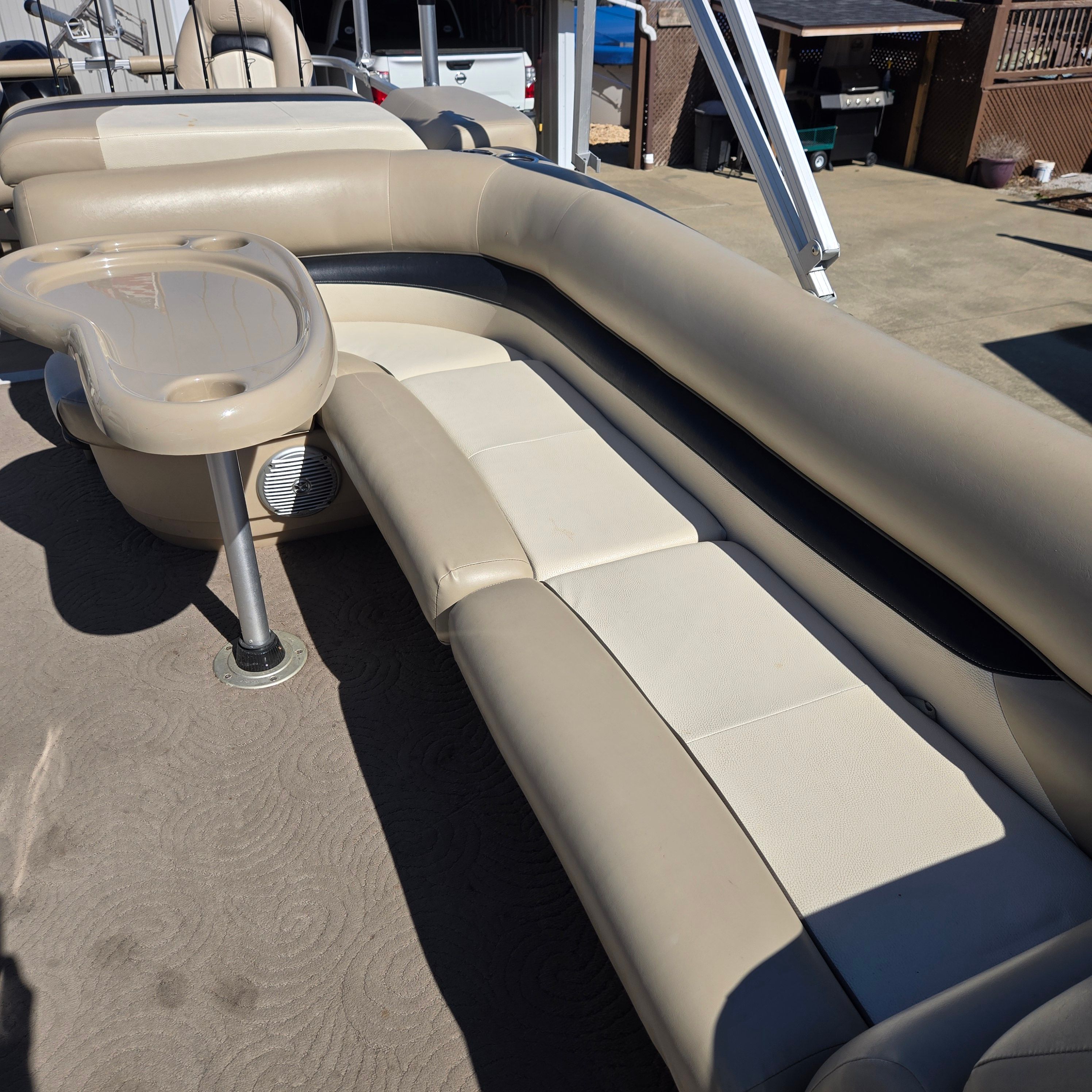Interior view of a Sun Tracker Fishin' Barge 24 DLX with beige seating.