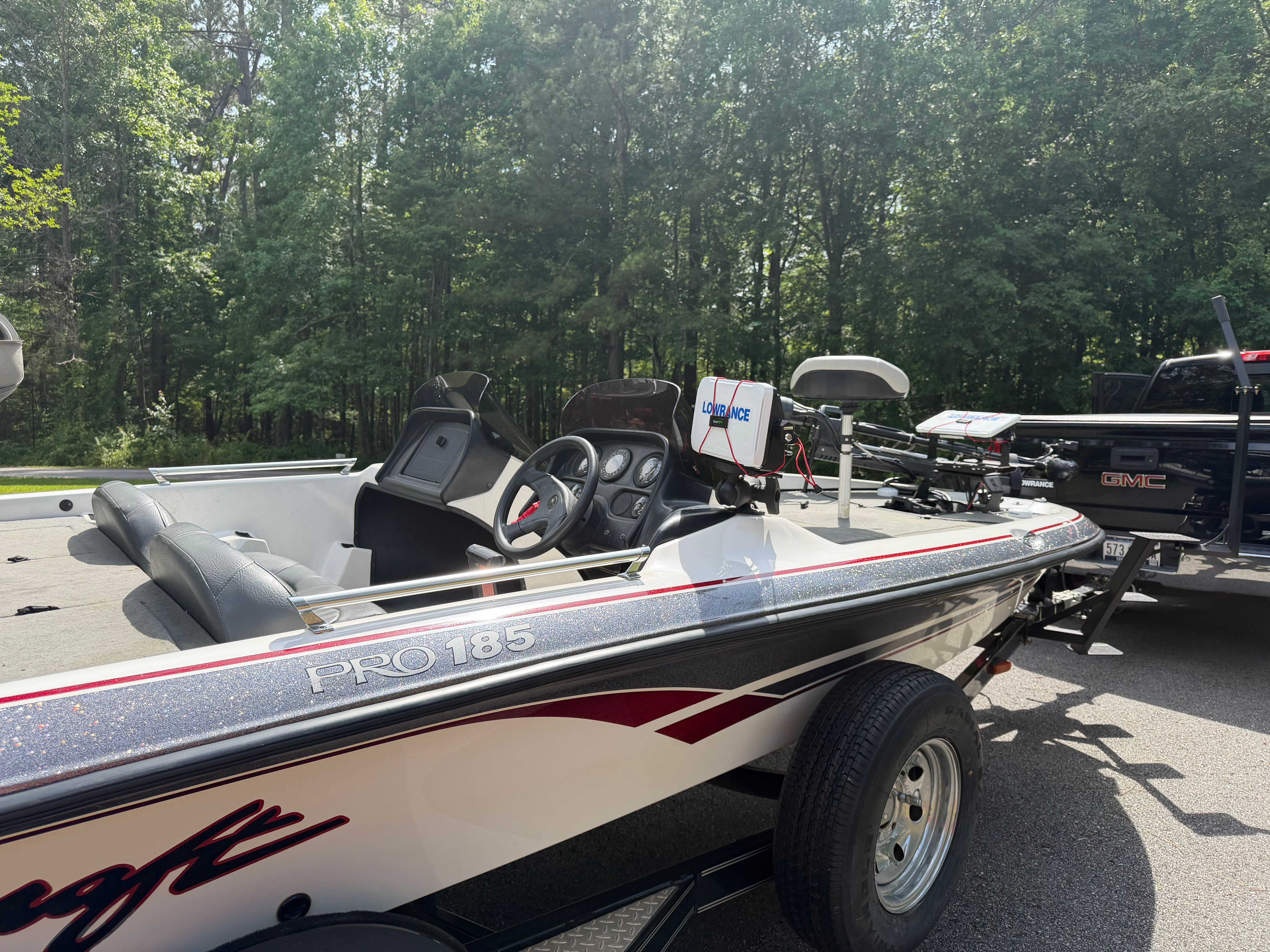 A 2001 ProCraft Pro 185 SC/DC boat on a trailer, surrounded by trees.