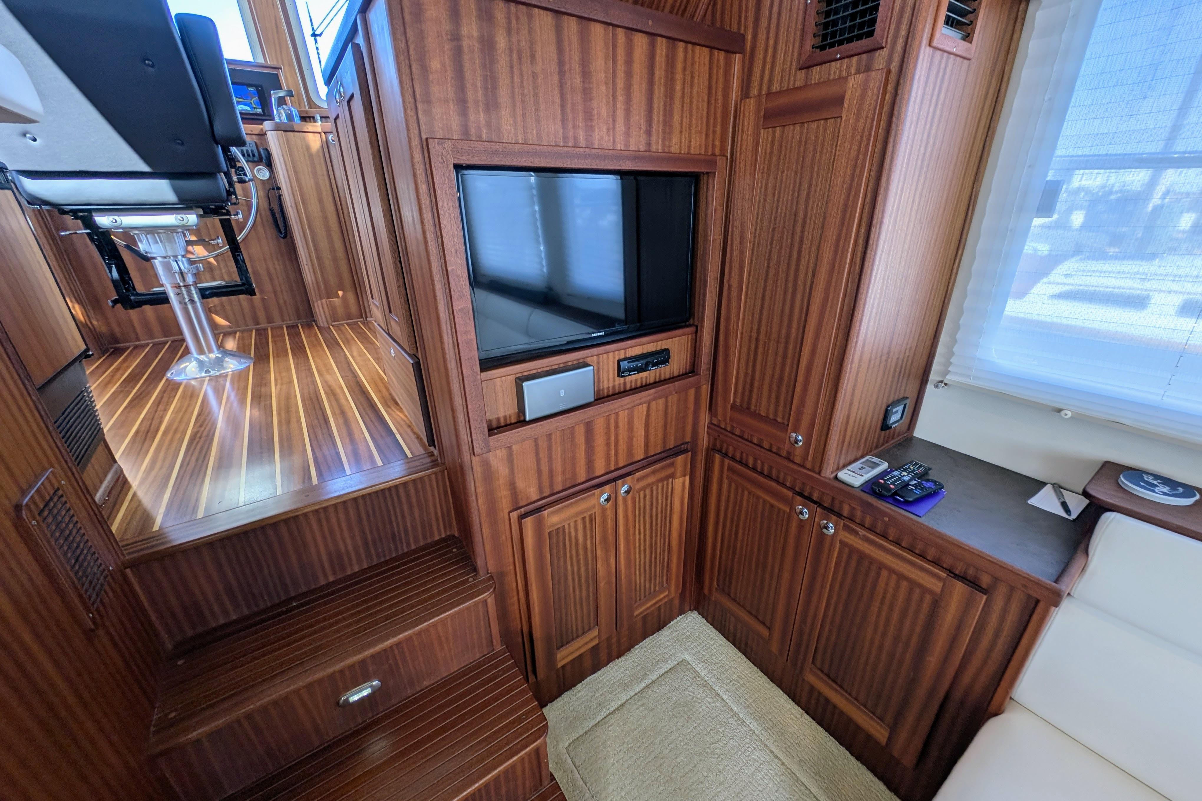 Interior of 2015 American Tug 435 with wood paneling and built-in TV.