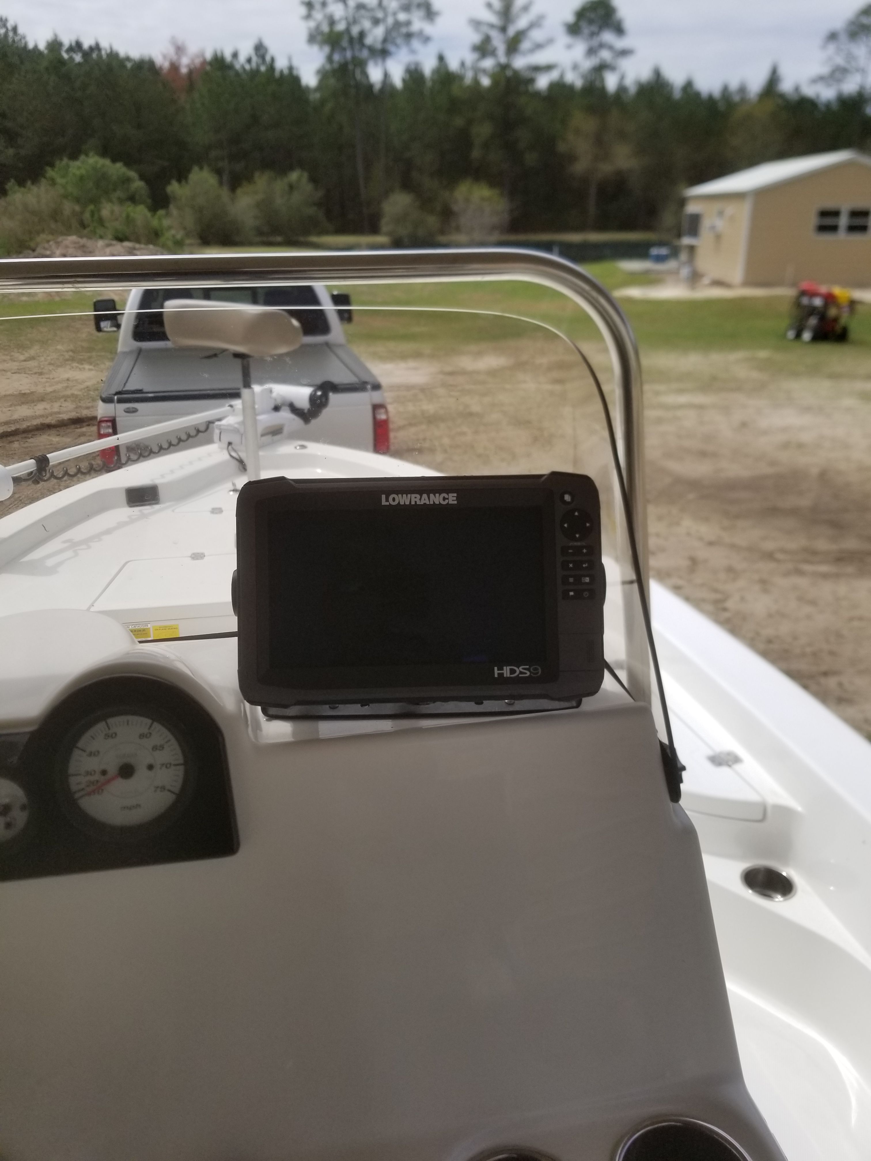 A boat with a navigation system and a trailer in the background.